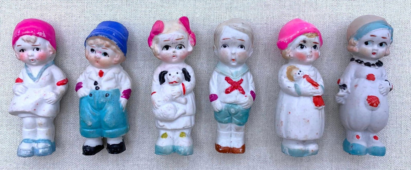 Six 1920s JAPAN Bisque Arcade Penny Dolls: JAPAN marks on most, each approx. 3 3/8" to 3 5/8", hand painted in vibrant colors.