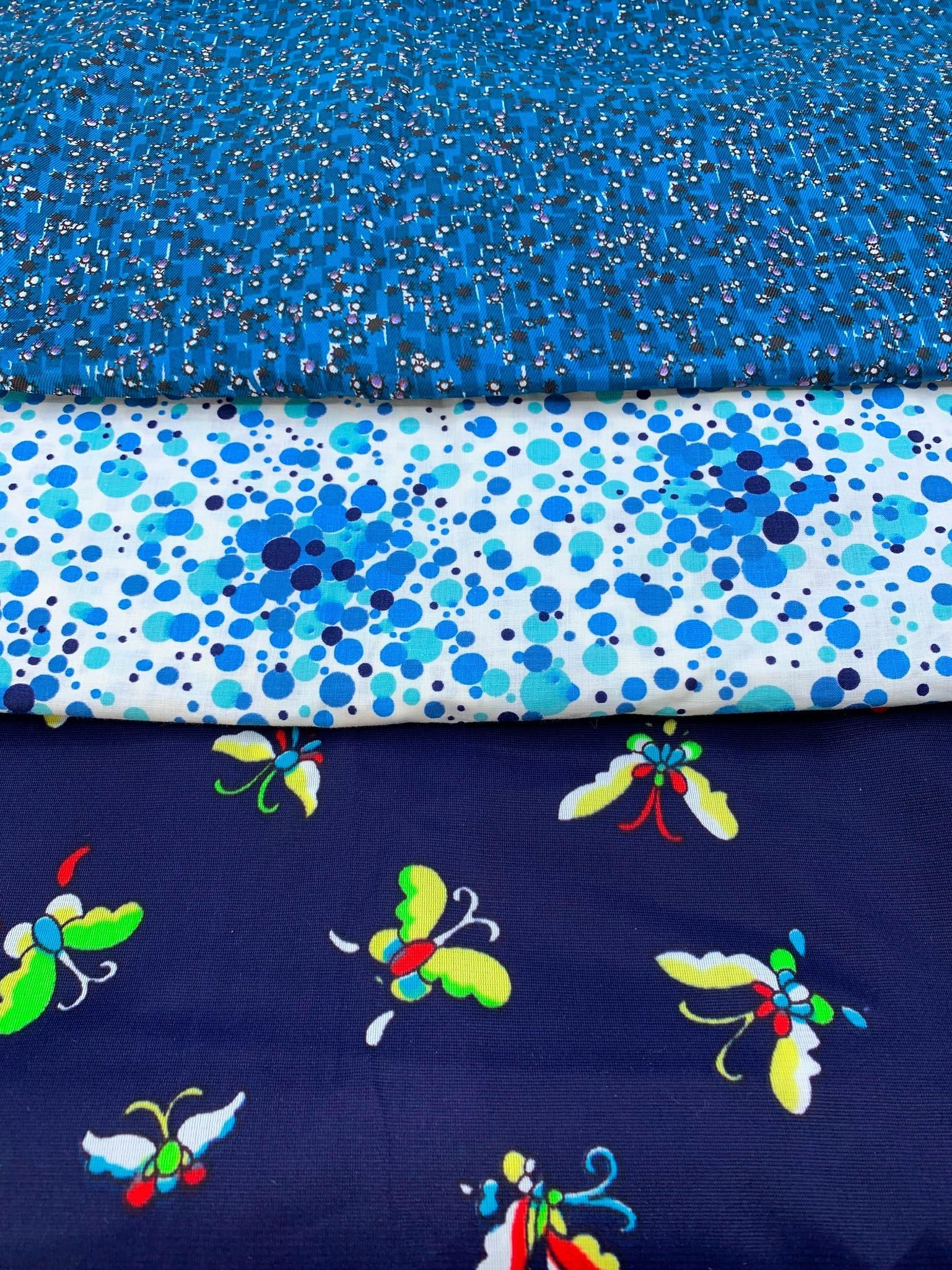 3 Single Lengths of New Old Stock Unused Vintage Mid Century Garment Fabric: * 44; x 1339; single length poly blend butterfly fabric, rich even hues* 40; x 1339; single length shimmering azure blue black splotch star heavyweight dress fabric* 35; x 939; single length sapphire,
