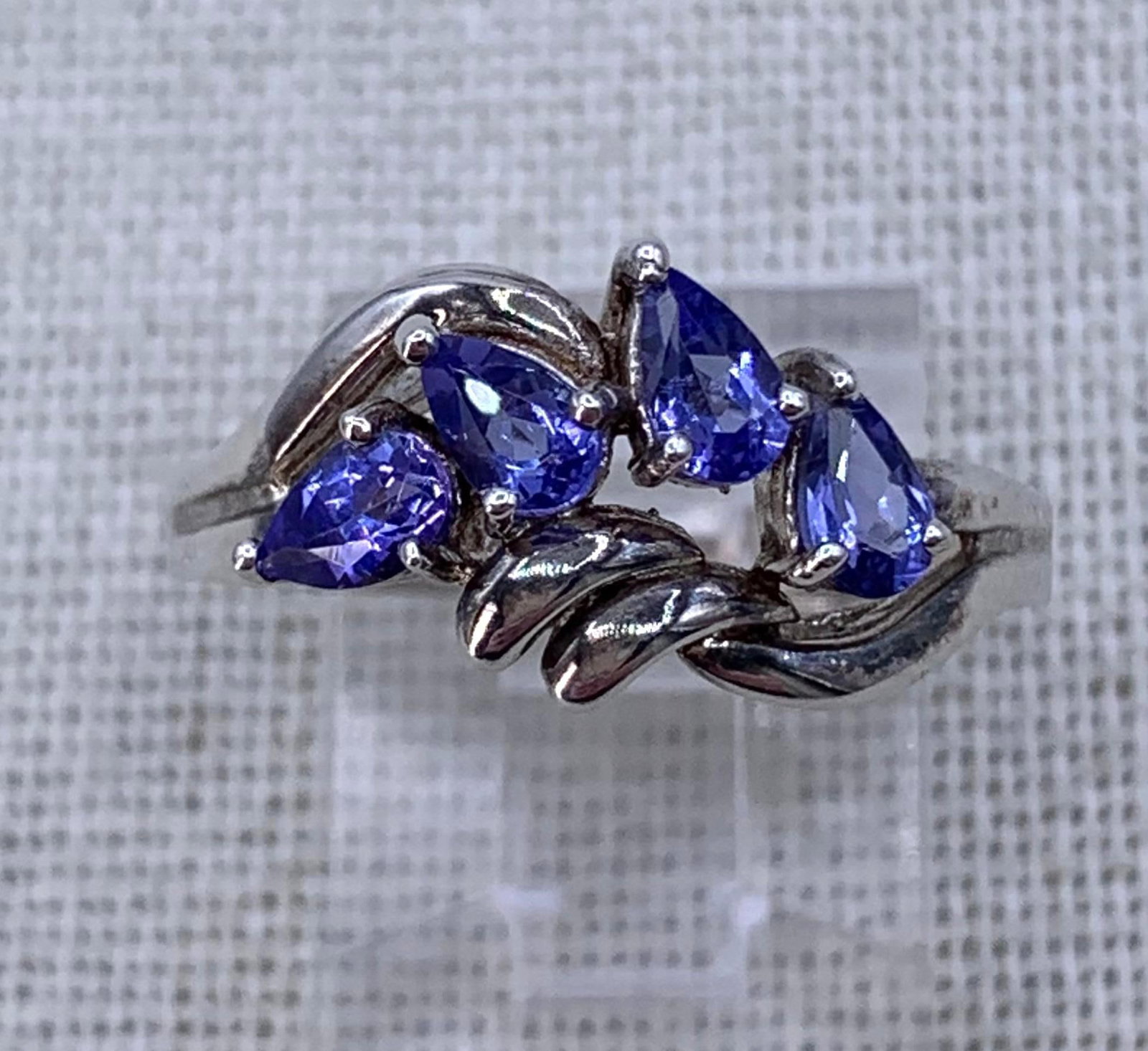 Radiant Tanzanite Sterling Silver Pear Shaped Gemstone Love Knot 925 Ring: Gorgeous glitter and hue to the Four 4x2mm pear shaped Tanzanite gemstones, unique asymmetrical openwork knotted sterling framework, STERLING hallmark, size 8.75, 3.7 gram weight.