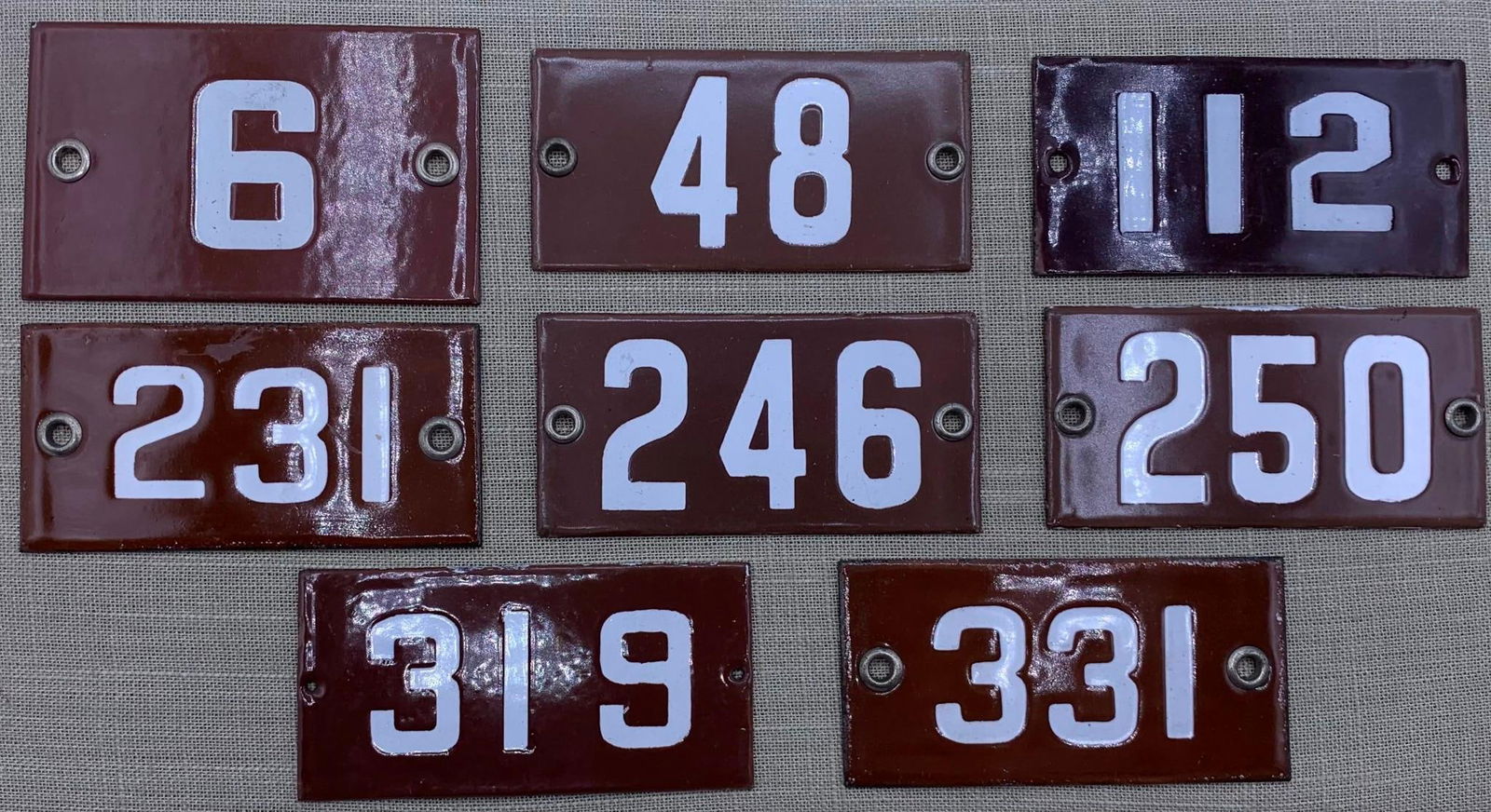 8 Vintage 1920s Porcelain School Classroom Number Signs: Hefty in weight with metal grommets. light age and wear to the porcelain, 4" x 2".