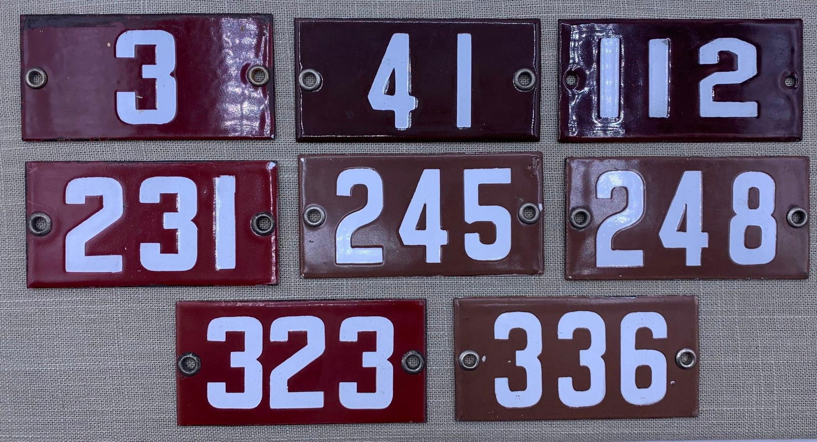 8 Vintage 1920s Porcelain School Classroom Number Signs: Hefty in weight with metal grommets. light age and wear to the porcelain, 4" x 2".