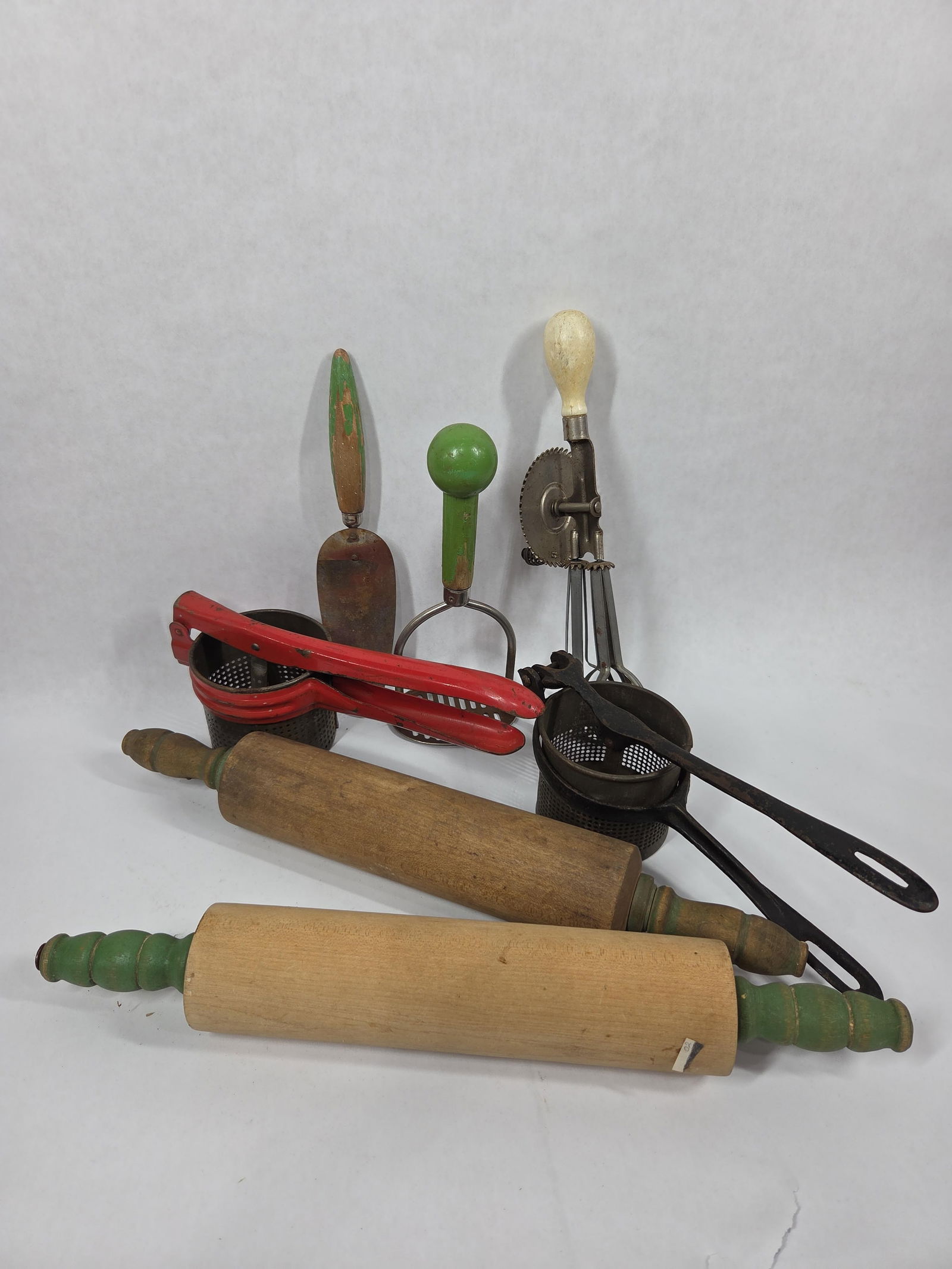 Kitchen Primitives: Green handled rolling pin, ricers, beaters, and more.