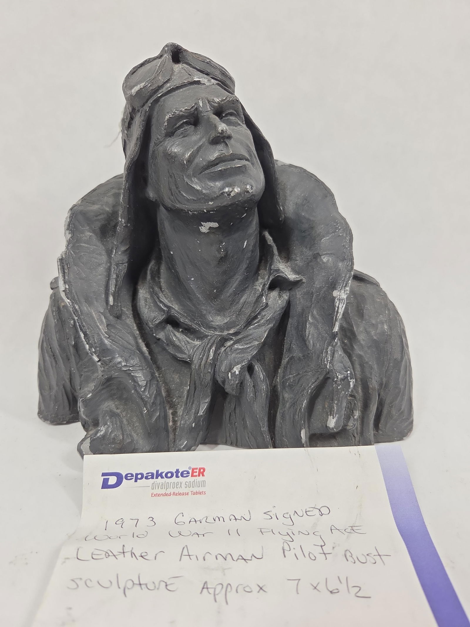 1973 Garman Signed WW2 Flying Ace Bust: Airman pilot with very detailed lines. Signed Michael Garman. 7x6.5. Cast metal, shows a few minor chips to coat edge.