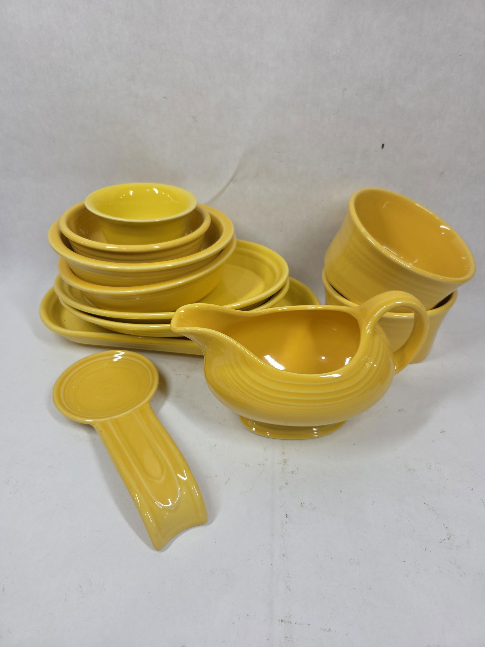 Sunflower Yellow Fiesta Gravy Boat, Platters, Spoon Rest, and Bowls: 11 pieces, all in good condition.