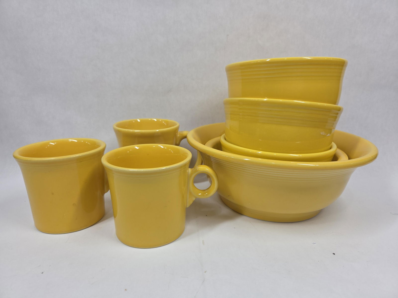 Sunflower Yellow Fiesta Serving Bowls, and Mugs: 8 pieces all in good condition.