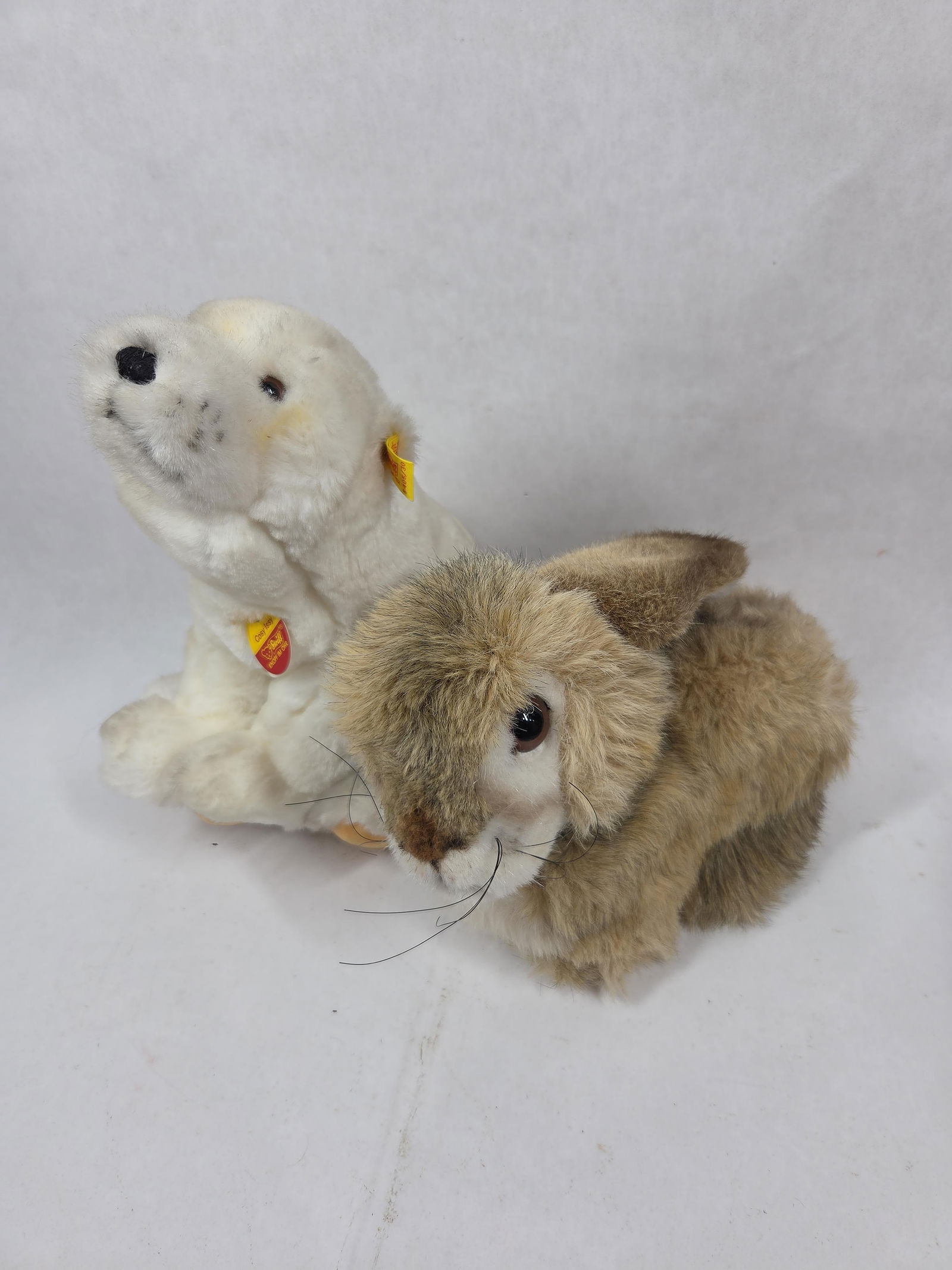 Steiff Rabbit and Cosy Issy Polar Bear: Cosy Issy bear shows minor small stains, tag number 5405/30. 11 inches. Dormy stuffed rabbit with tag number 2975/25. 10 inches