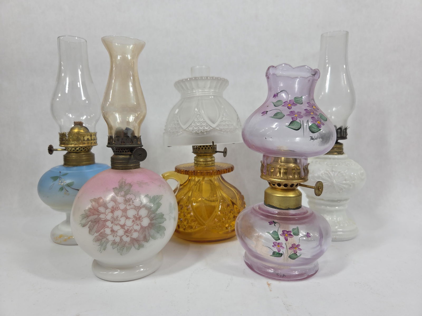 Miniature Hand Painted Oil Lamps: Includes an Imperial amber glass finger lamp with satin glass shade. All include chimneys. 7 to 9.5 inches tall