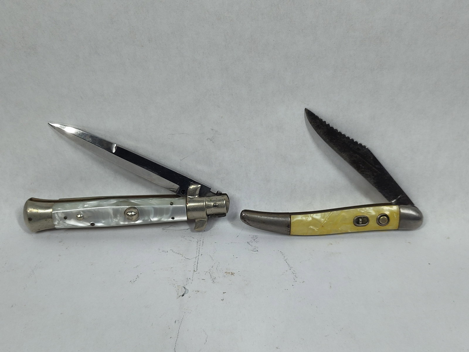Spring Action Pocket Knives: Hammer brand and Rostfrei 411 switchblade. Both knives feature opal swirl handles and clean blades. Spring action works.