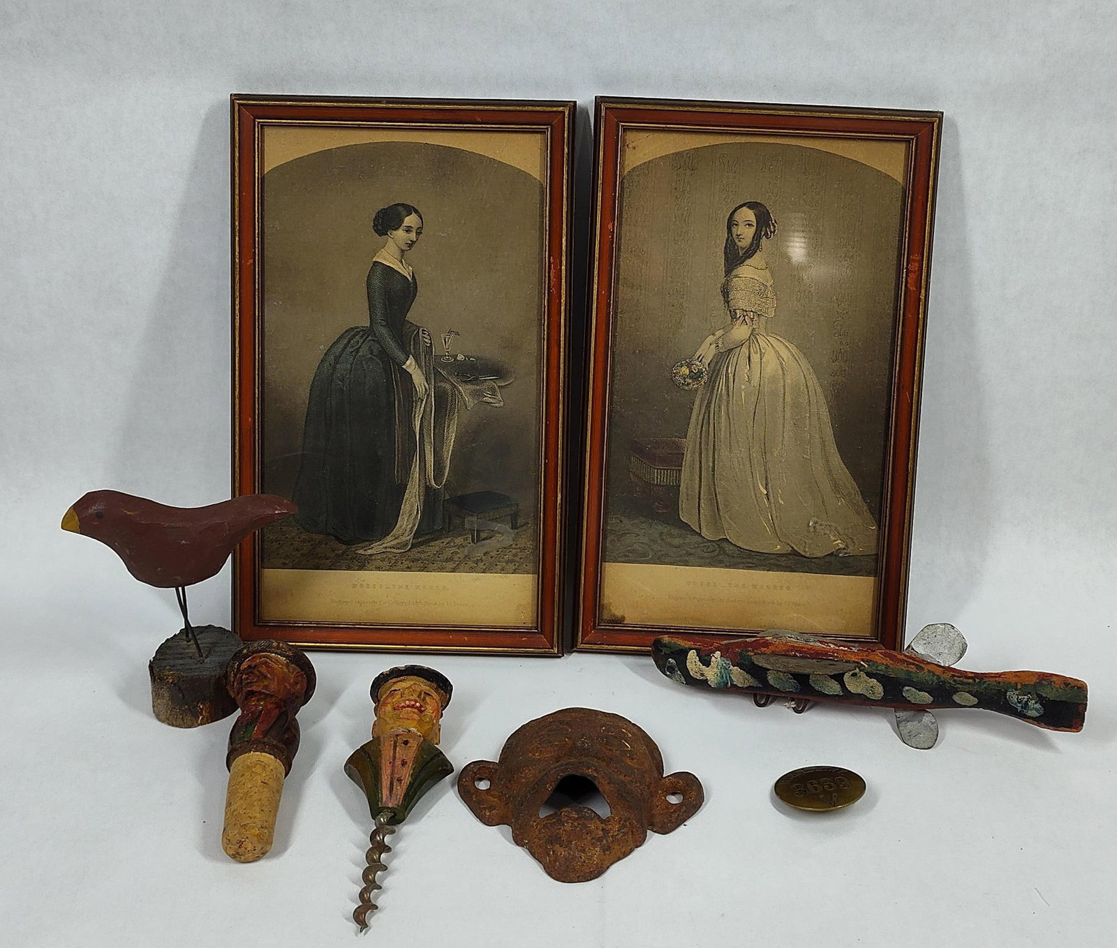 1800's Framed Fashion Plates, Hand Carved Wooden Lure and Cork Toppers, CI Bottle Opener, RR Badge: This great primitive collectible lot includes 2 framed fashion plates, carved corkscrew and bottle cap, RR badge, cast iron bottle opener 