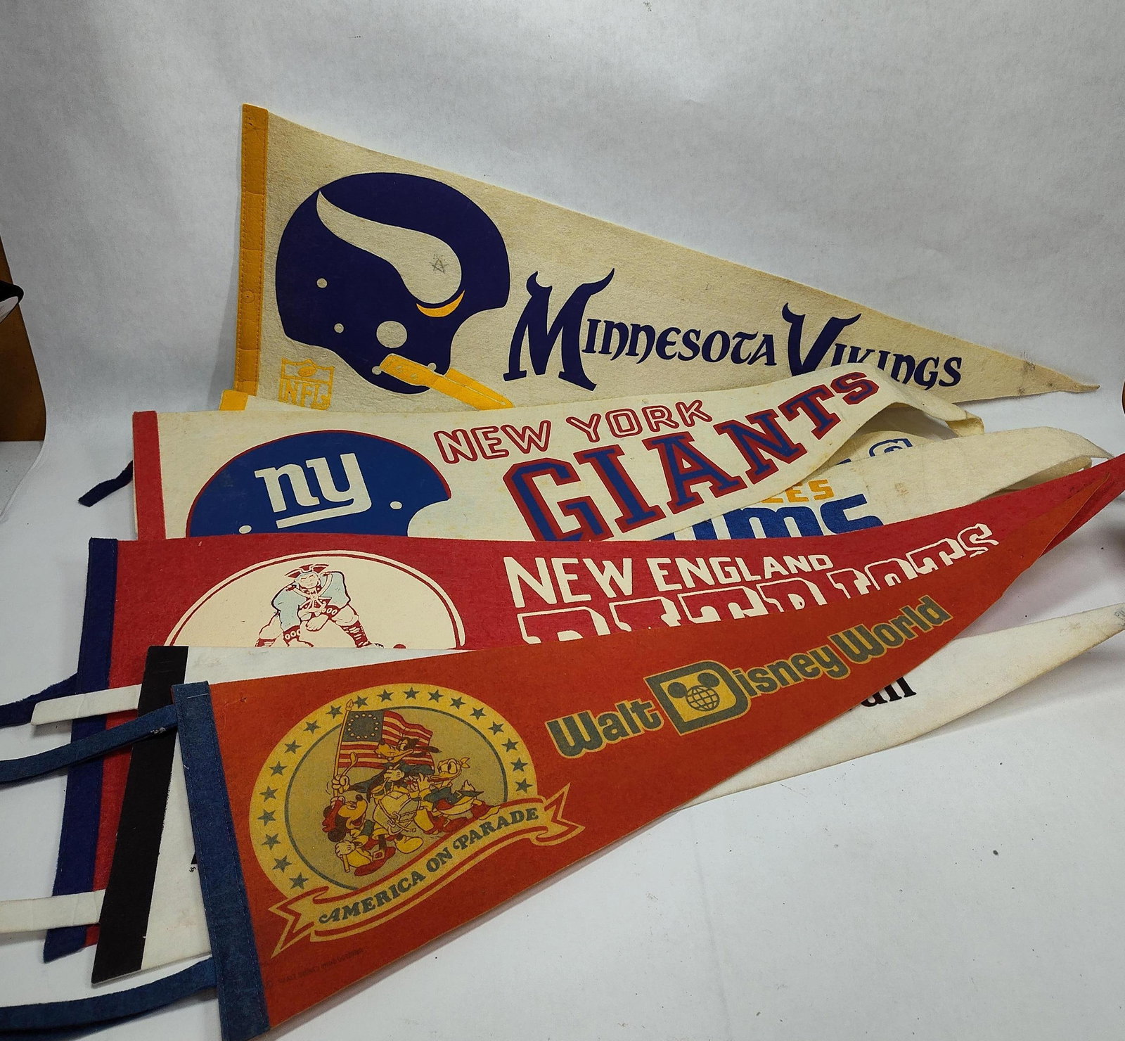 1960's and 70's Felt Pennants Inc. Walt DIsney, NFL, Philadelphia, Giants, Rams and Vikings: This great collectible lot of assorted pennants would make a wonderful addition to any collection all being in good vintage condition showing only minor areas of soiling this lot includes 7 various pe
