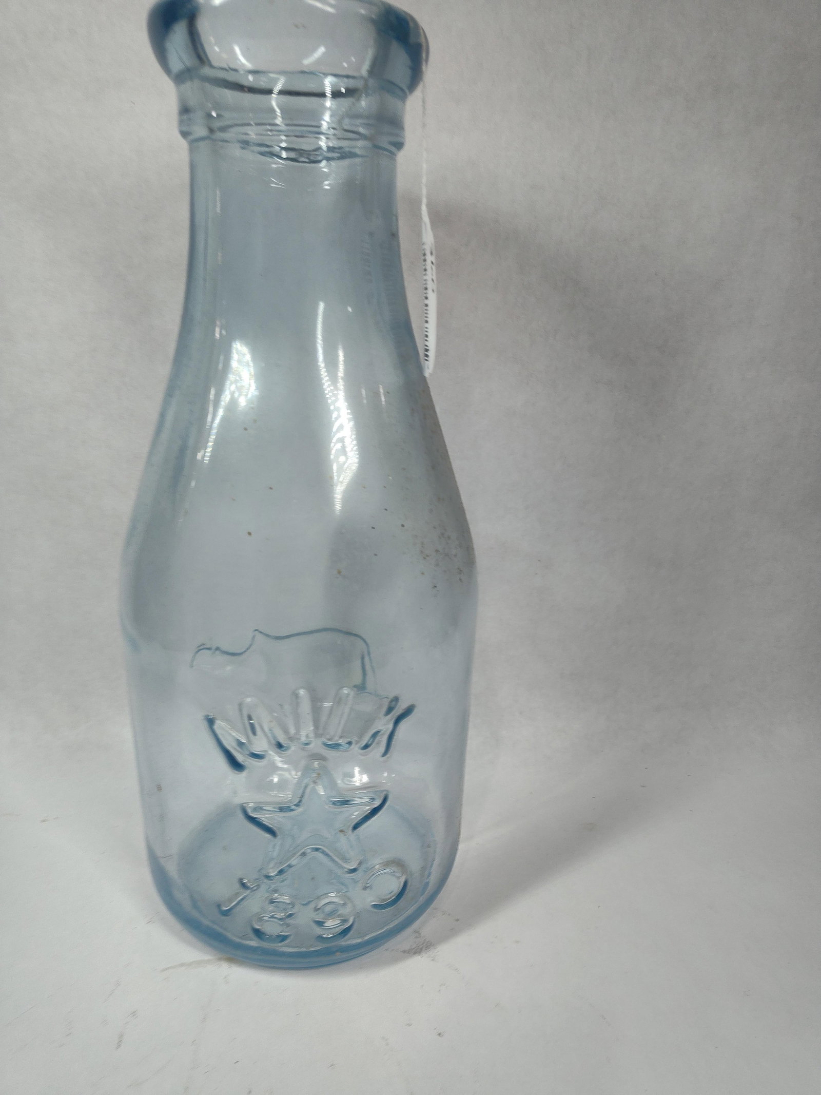 Large Glass Novelty Embossed Dairy Bottle: This great bottle is in great condition with no chips, cracks or breaks showing a dairy cow to one side and Milk 1890 with a star fully embossed standing 18 in. H 