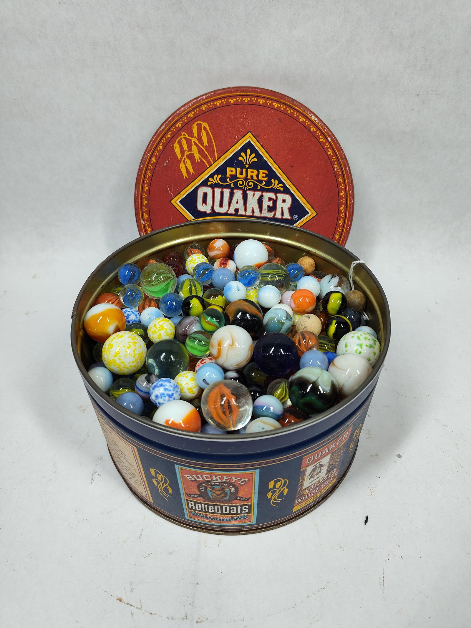 Early Mix of Hand and Machine Made Glass, Clay, Peltier and More Marbles in Lidded Tin: this great lot of marbles is loaded with many varieties, makes, colors and sizes as seen in photos 