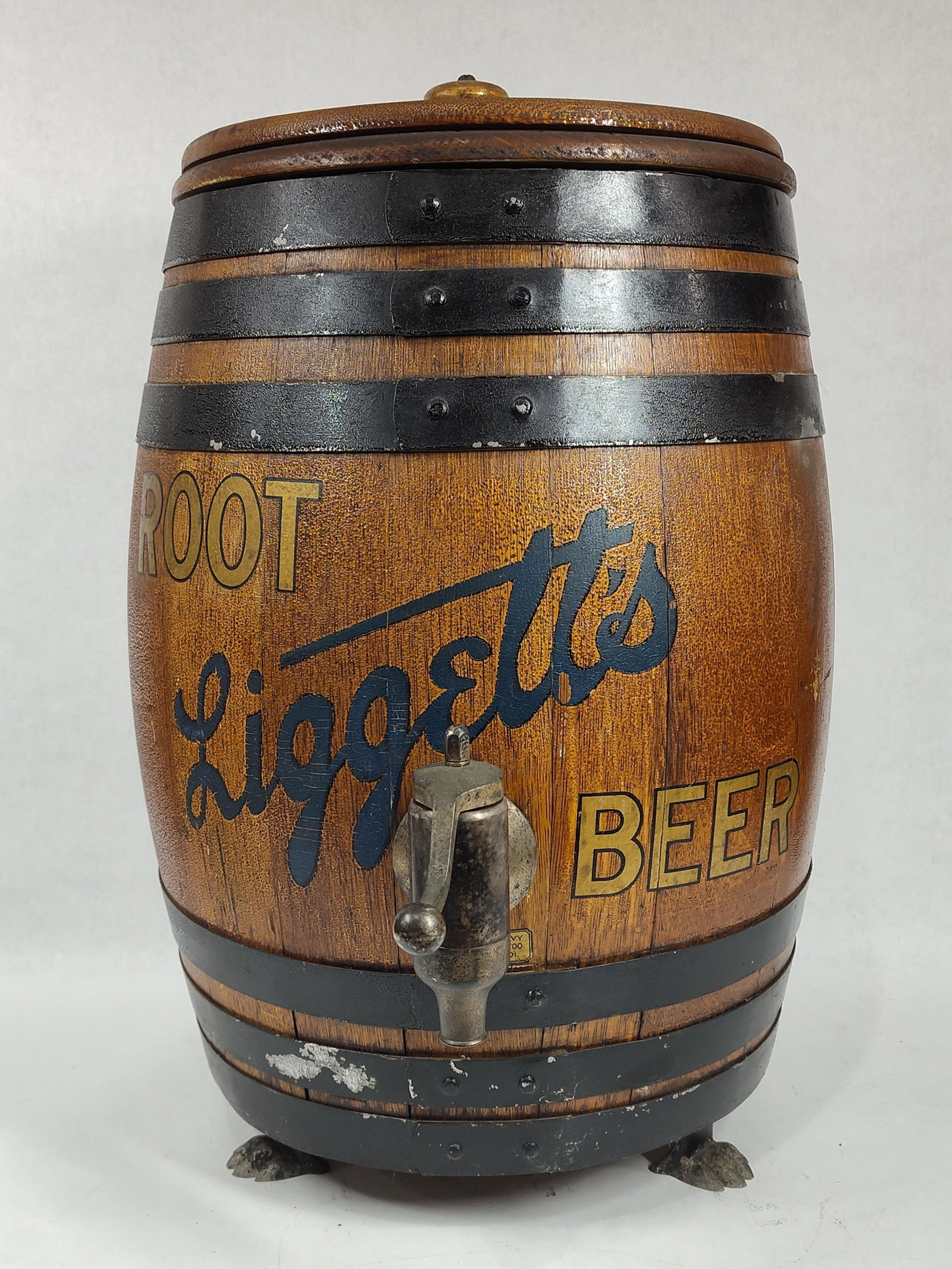 Liggett's Root Beer Barrel Dispenser: With interior apparatus, claw feet and appears to be with original surface. 21in tall 12in diameter at top.