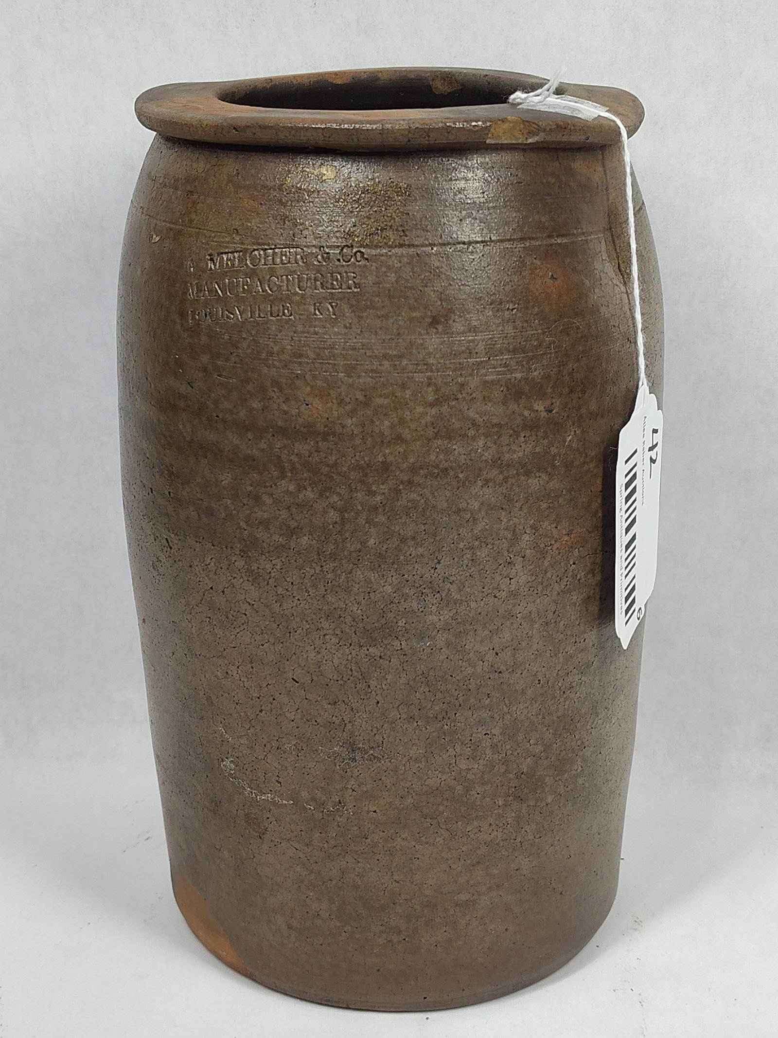 A. Melcher & Co 1gal stoneware jar: Louisville, KY. Shows a few small chips on rim and some age spidering. 10.5in tall.