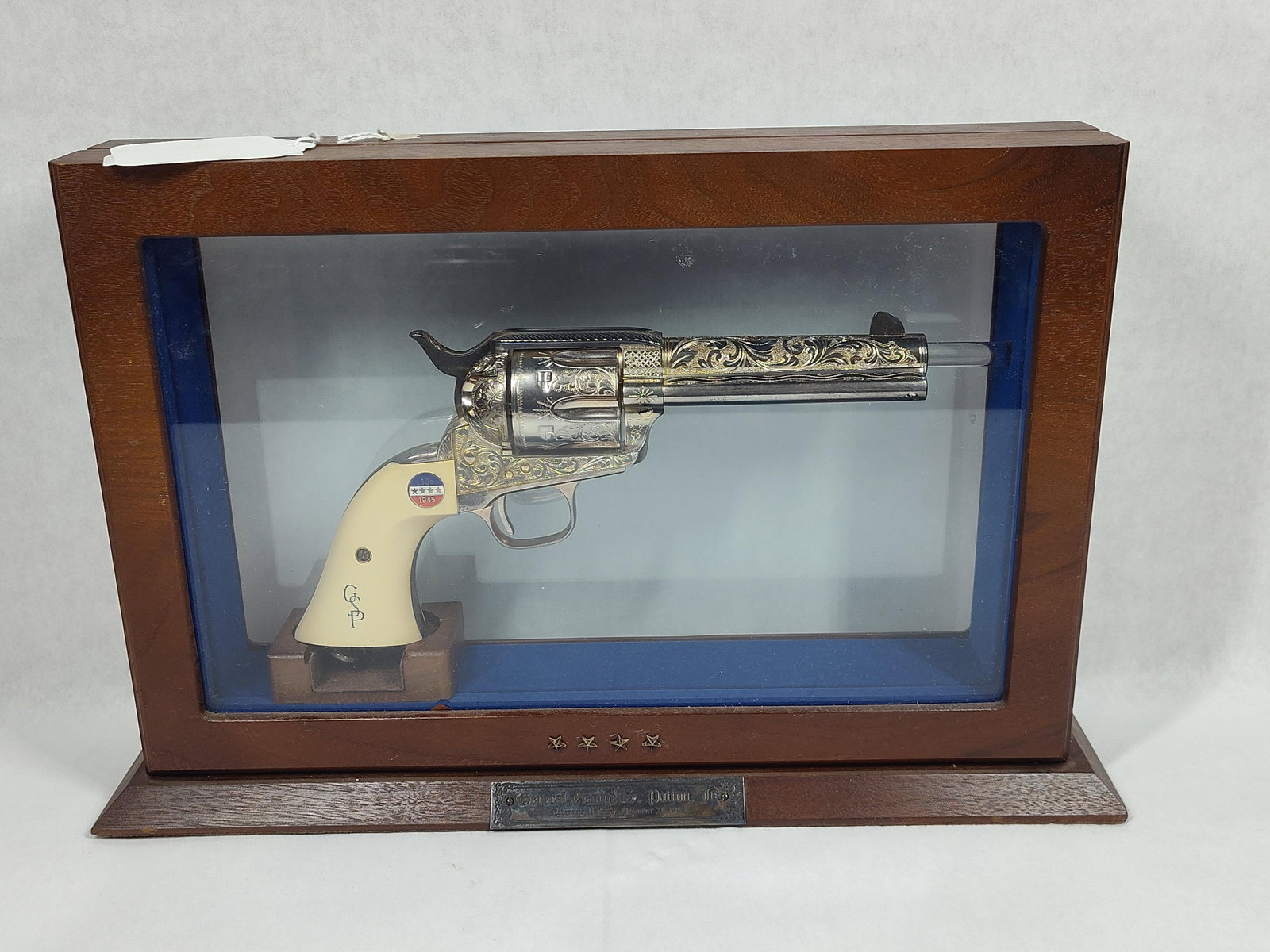 Highly Engraved Uberti George S. Patton Commemorative Revolver in showcase: Beautiful engraved and silver plated Uberti Single Action Army Revolver in .45 LC caliber commemorating General George S. Patton Jr. Ornate scroll work on receiver and barrel, with GSP initials and
