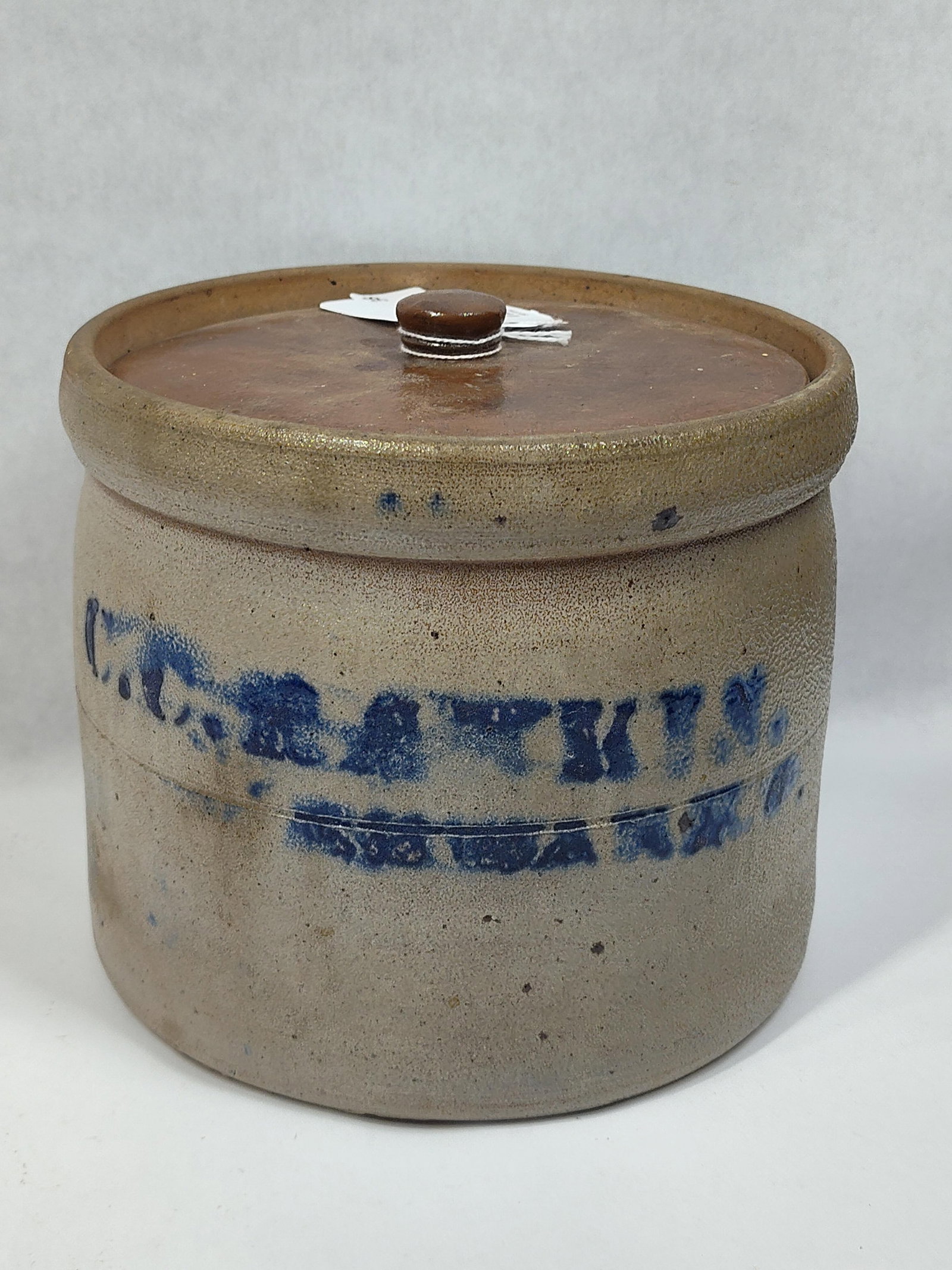 Stoneware Butter Crock w/ Lid: Shows a small chip on rim, otherwise in great condition! With a stenciled name but is smudged and hard to read. Upon first impression appears lid may not be original but is the color as the interior,