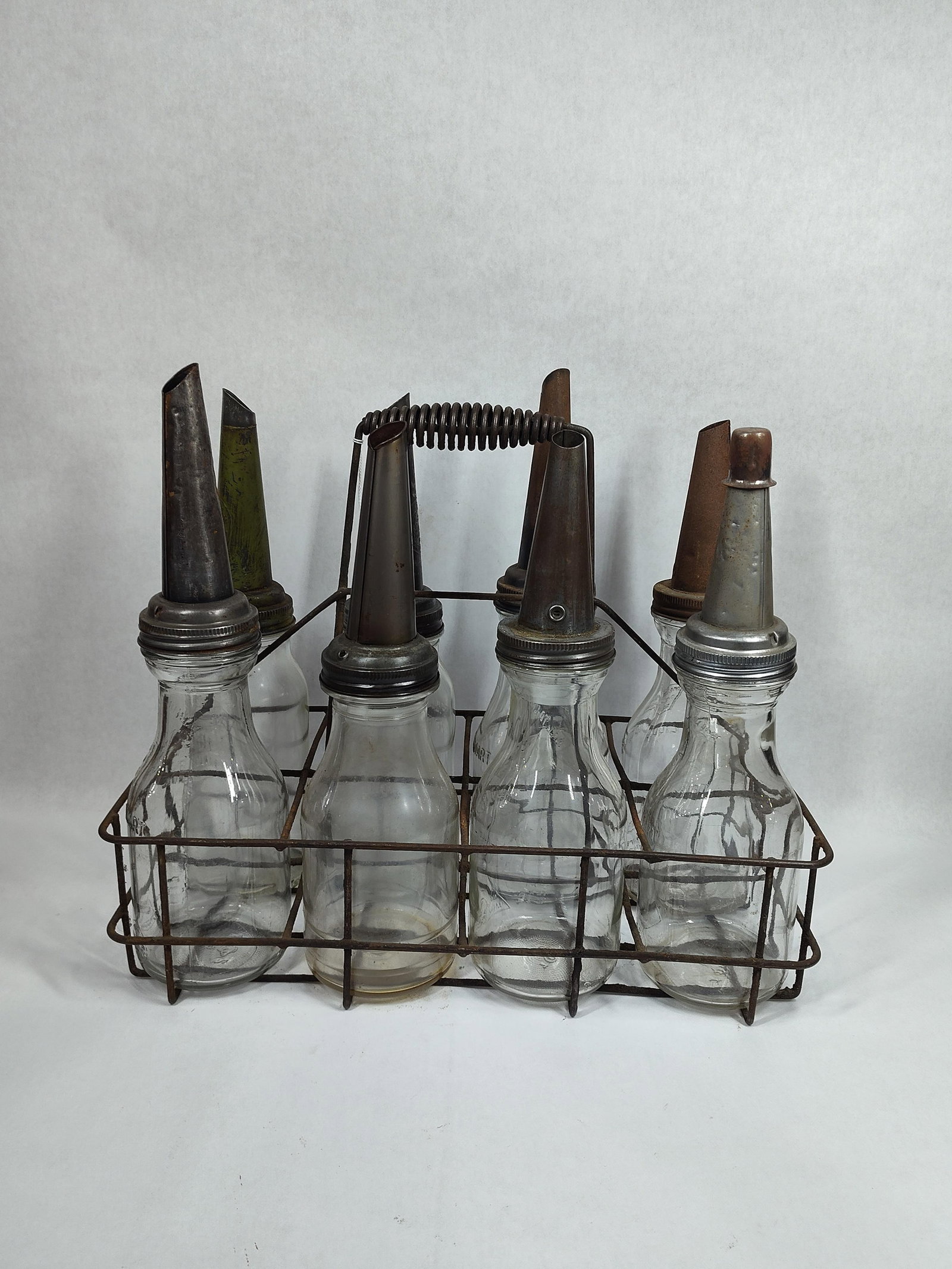 8- Various 1qt Oil bottles with carrier: 5 are identical, 2- Moore & Kling and 1 other.