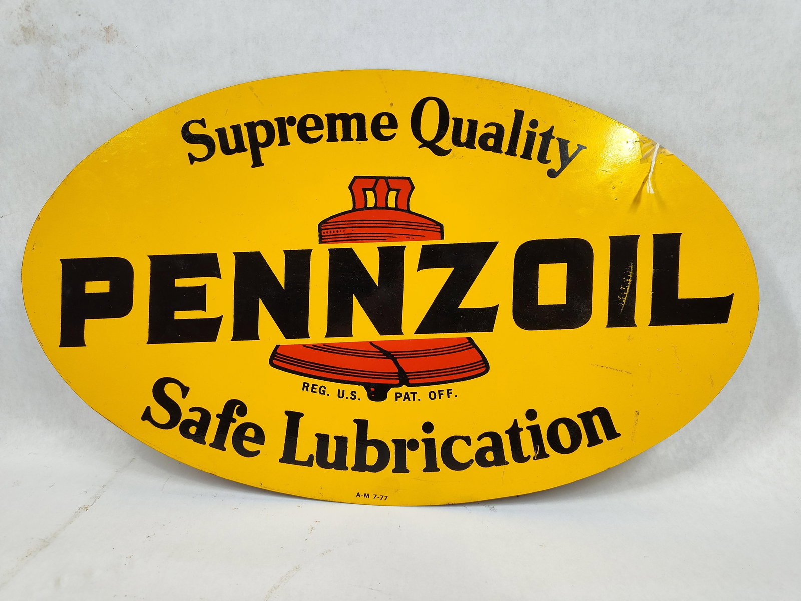 DST Pennzoil Oval sign: 2-sided painted metal sign with 1 side in decent condition, other side shows some issues to paint and has SM-140 written on it with a permanent marker. Marked A-M 8-77. 9.75in x 16.5in.