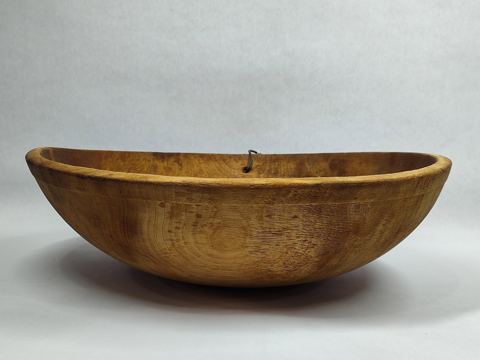 Primitive wooden butter bowl: Does have a crack from rim down approximately 5in to 6in. 17in diameter.