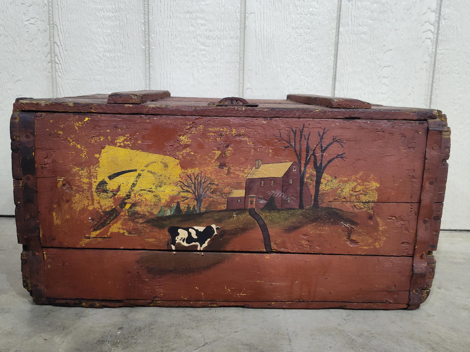 Early wooden crate with hand painted barn scene on front: Early red painted crate with hinged lid. 22.5in long 14in wide 12in tall.