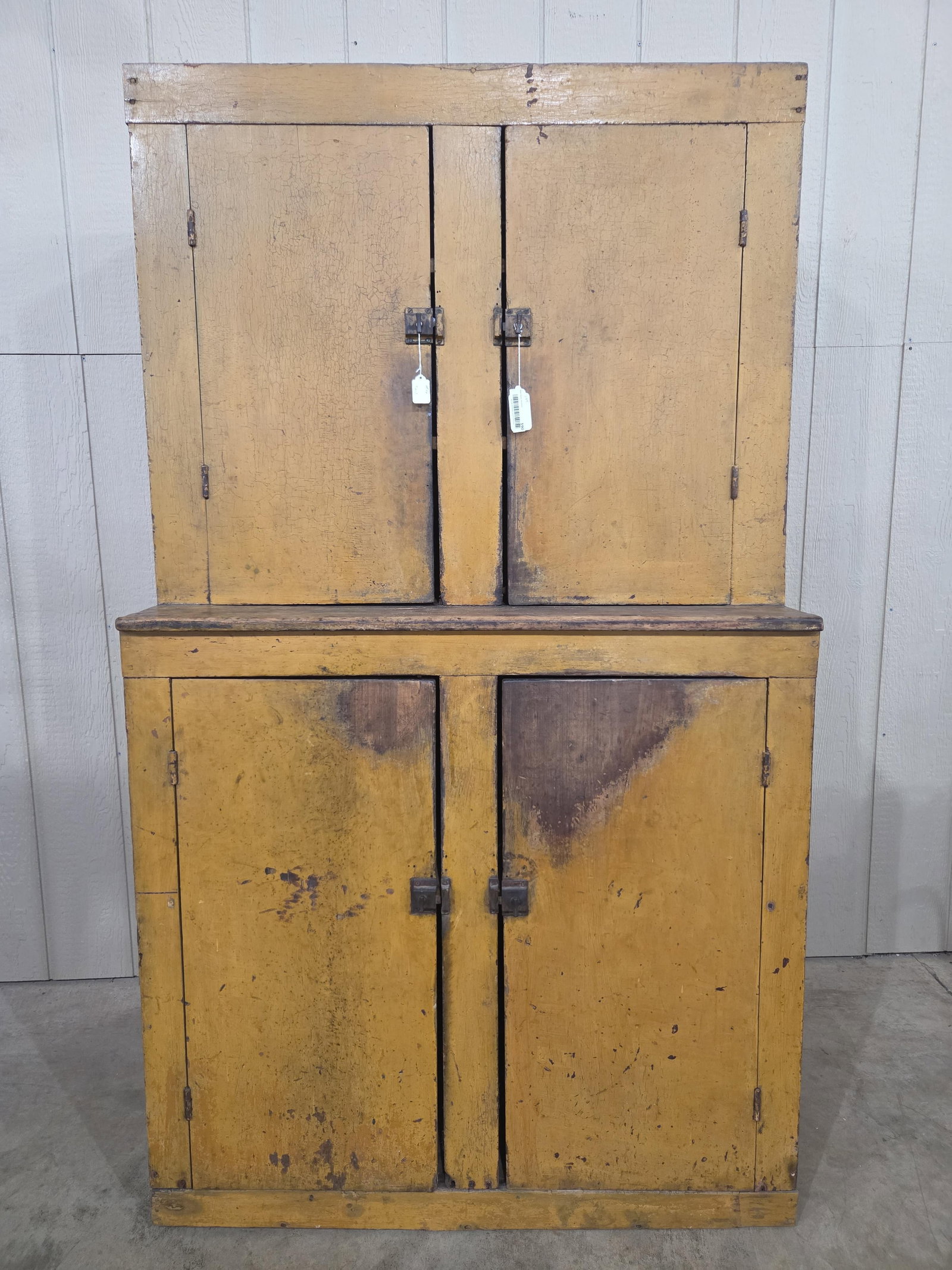 Outstanding early Primitive Mustard Stepback Cupboard: Great early sq nailed cupboard in mustard paint!! Shows some character but overall in great condition and has a awesome look!! 41in wide 20in deep 73in tall.