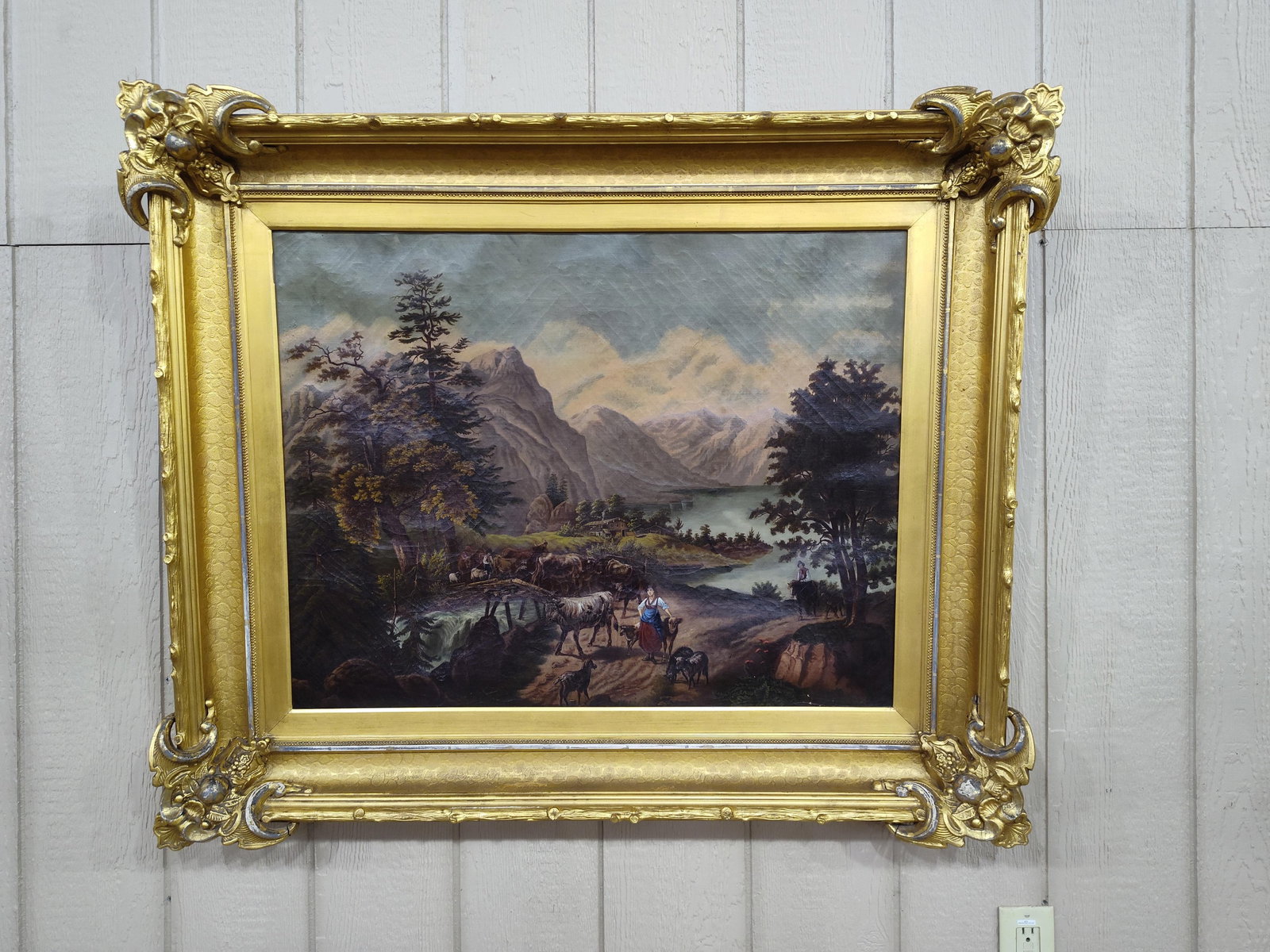 Mountain Landscape Oil on Canvas Painting in Fancy Frame: Beautiful oil on canvas painting in a highly ornate gold gilted frame! Painting shows age crackling with a couple tiny chips in lower right. Frame shows a few minor cracks in corner decorations but ov