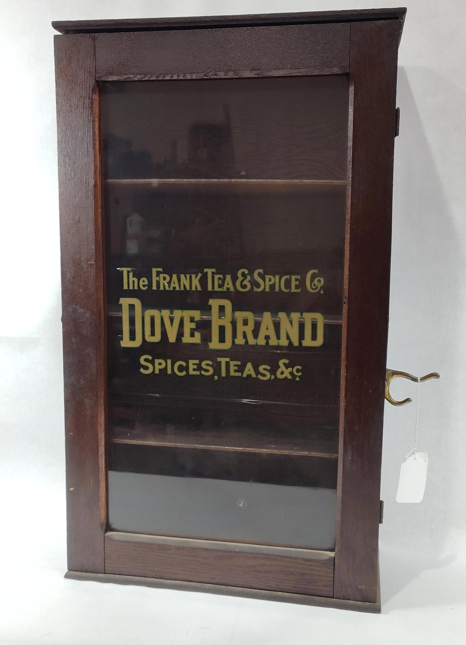 The Frank Tea & Spice Co "Dove Brand" Advertising Cabinet: Early oak or walnut cabinet with 3 fixed interior shelves and glass advertising panel in door. Has a great look!! 17.5in wide 8in deep 30in tall.