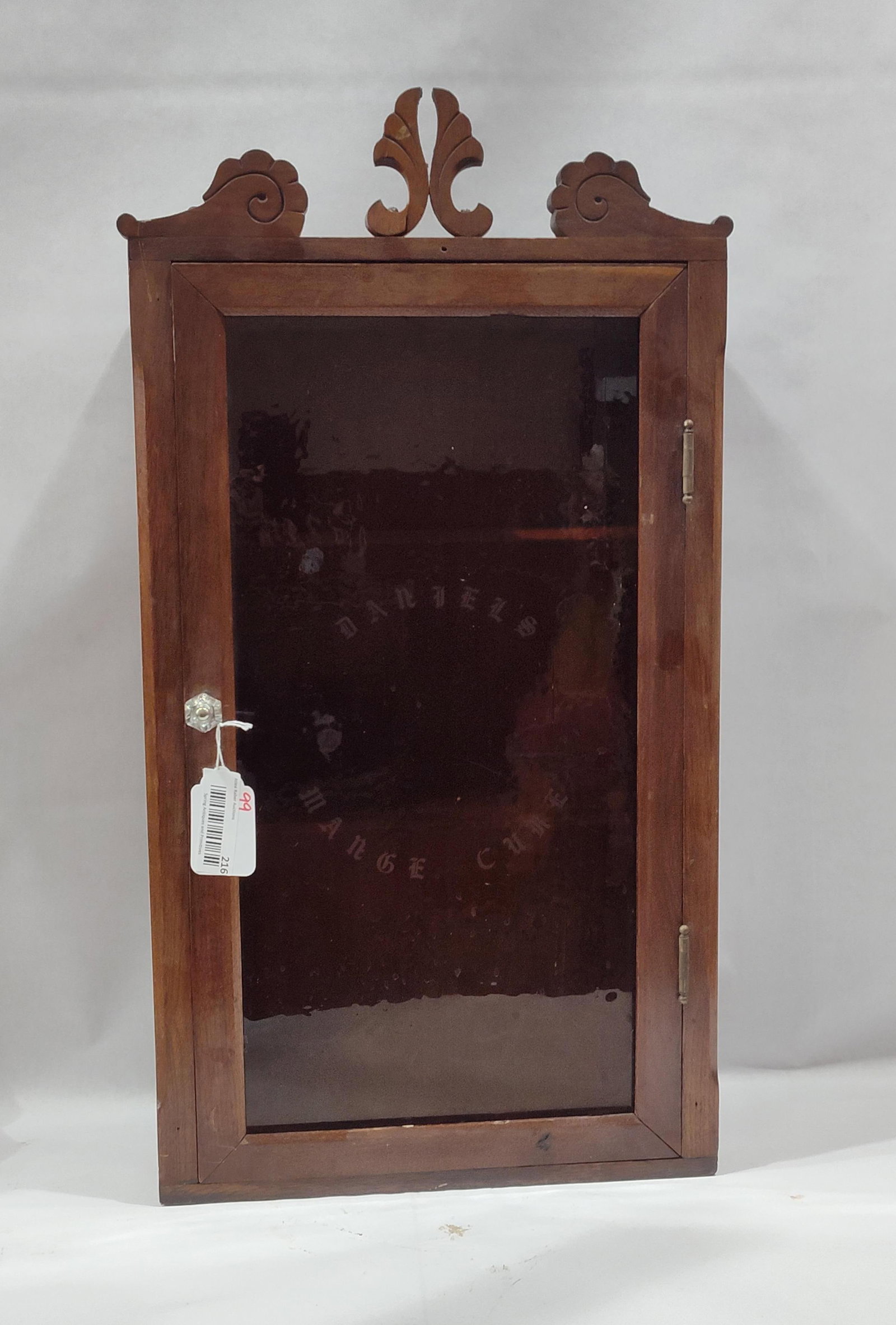Daniel's Mange Cure Wooden Medicine Cabinet: Nice early wooden hanging cabinet with amber wavy glass panel marked Daniel's Mange Cure. Top center crown has a break,otherwise is in good condition. 15in wide 7.5in deep 28in tall to crown.