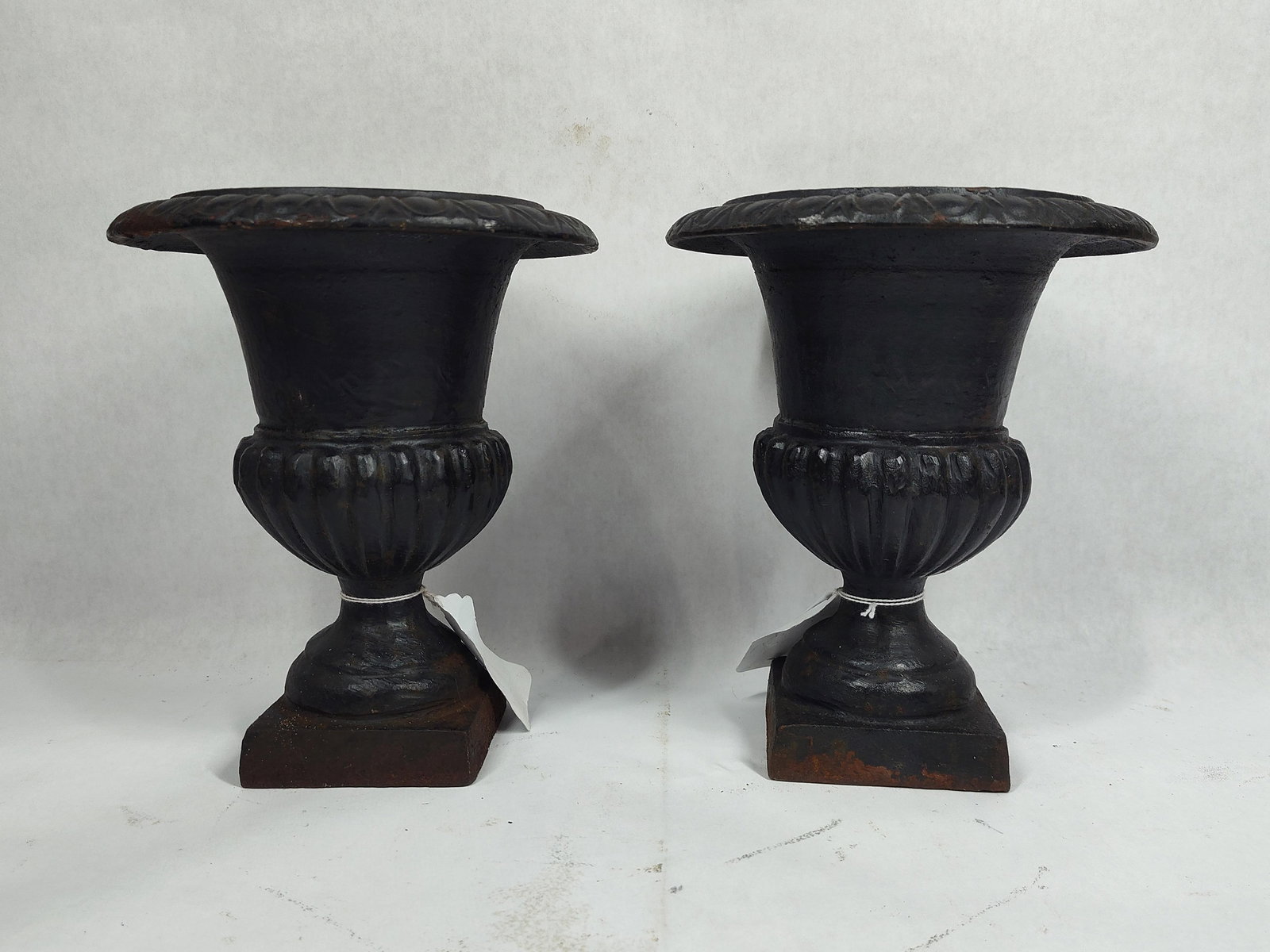 Pair of small cast iron urns: 7in diameter 9in tall.
