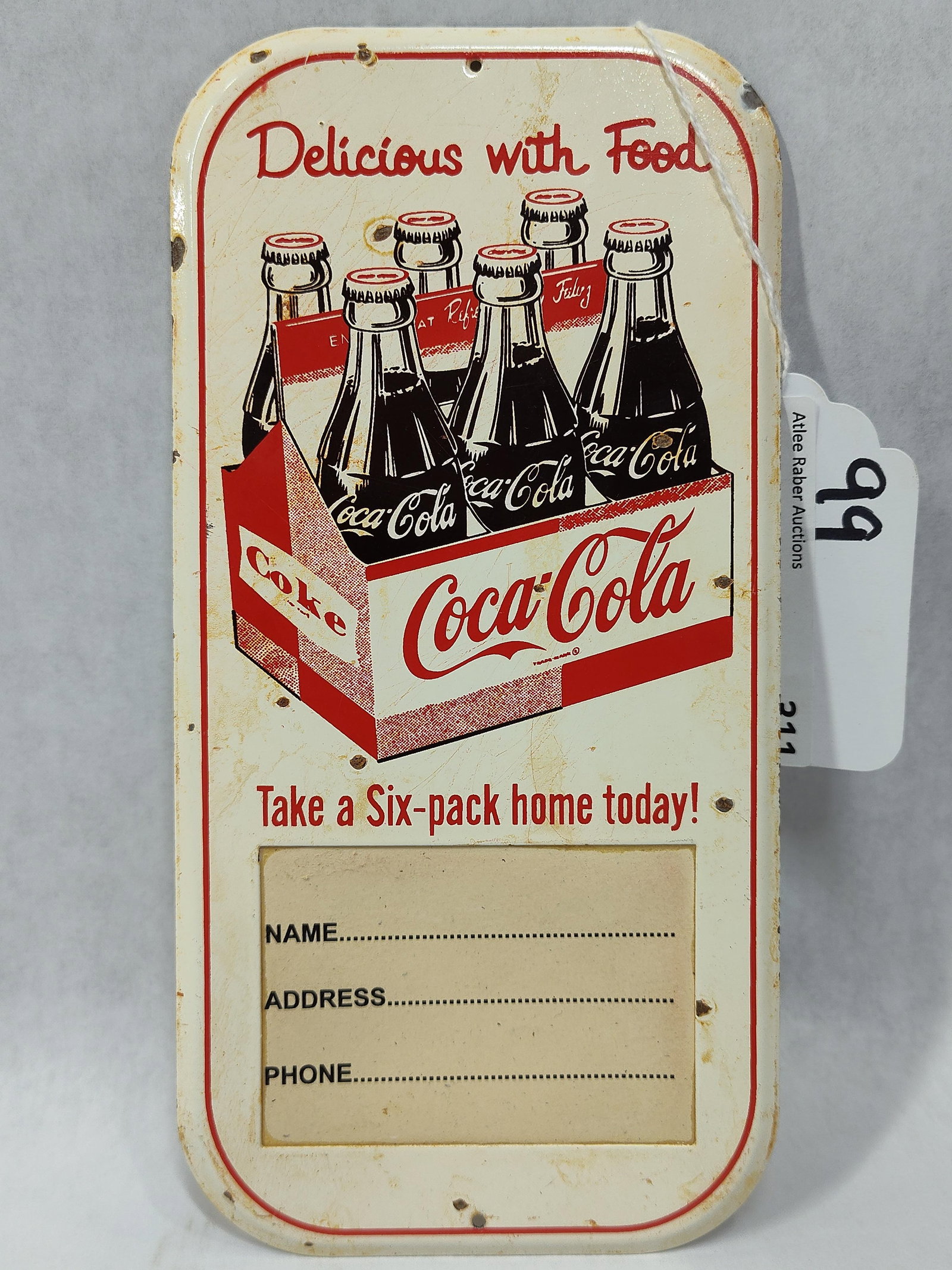 SSP Coca-Cola "Take a Six pack home today!" sign: Small 1-sided light porcelain plaque. Probably a pricer sign as it has a slot at bottom that appears someone added a cardboard name tag. 4in x 8in.