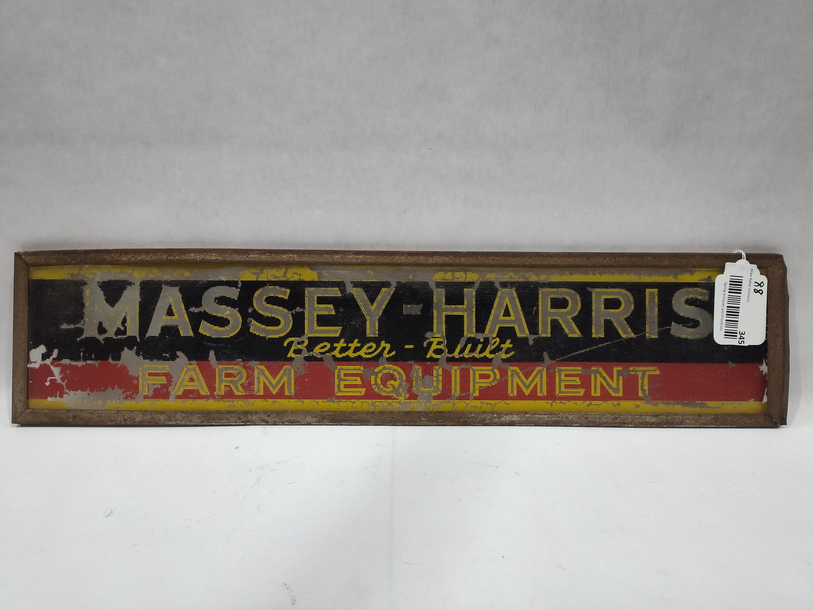 Early Reverse Painted Glass Massey-Harris panel: Reverse painted glass panel with metal frame. Shows paint loss and right side frame is bent. 5.5in x 25in.