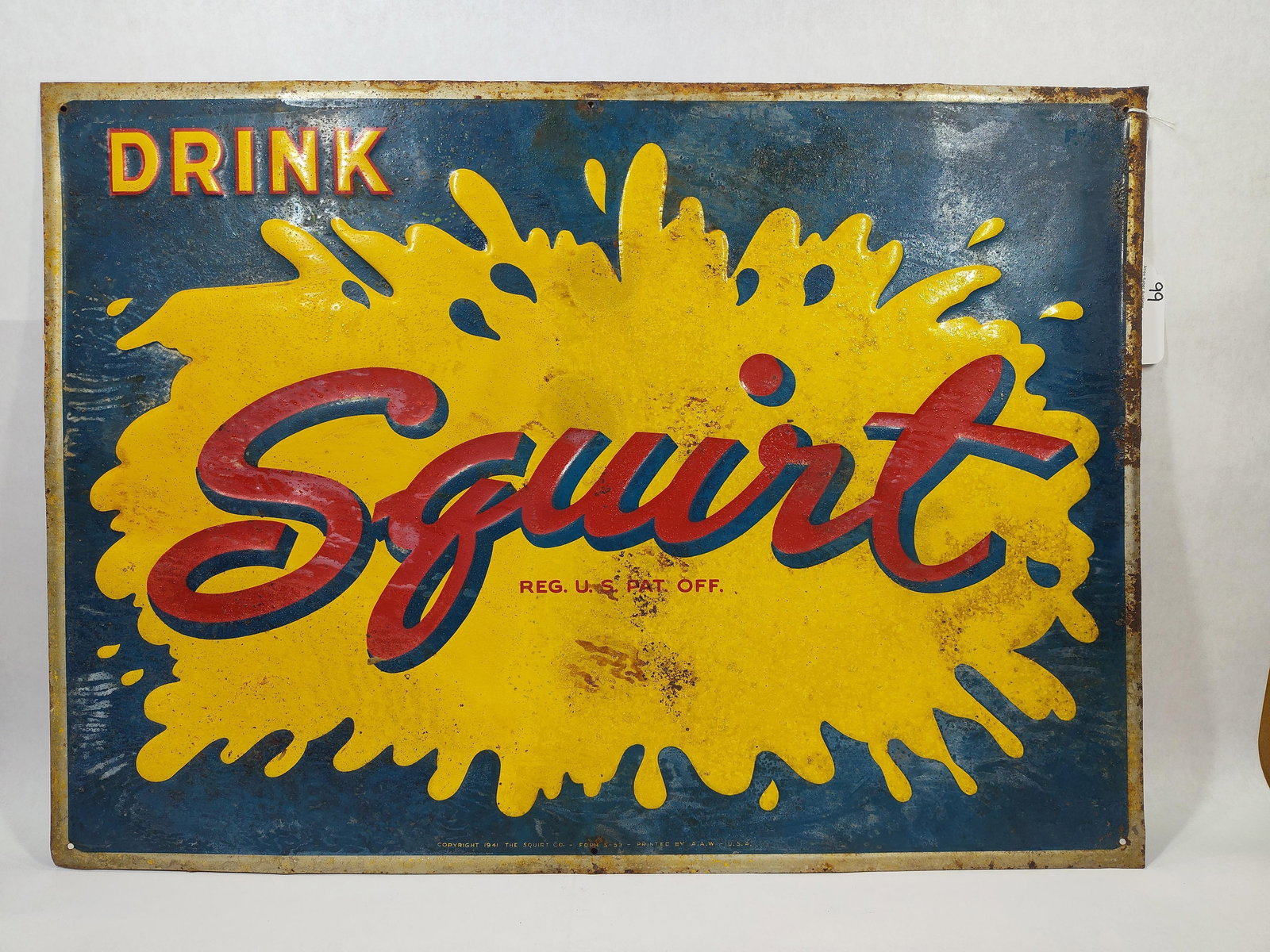 1941 SST Squirt Beverage embossed sign: 1-sided painted tin embossed sign with corrosion spotting and paper marks throughout but still displays well! 19.5in x 27.5in.