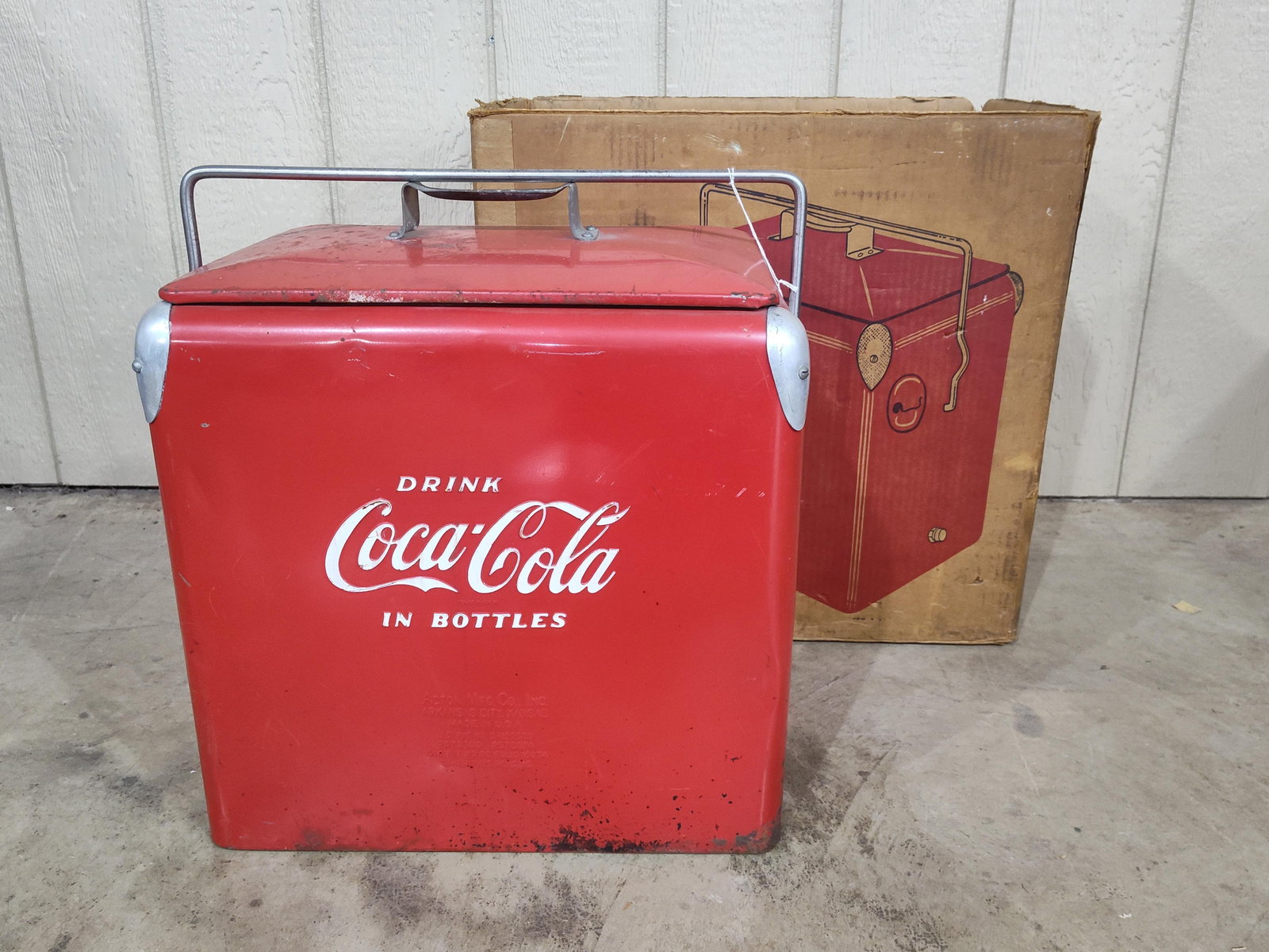 Coca-Cola Cooler with original box: Shows areas of corrosion spotting and some paint wear but overall in decent condition. No interior tray. 17in long 12in wide 17in tall.