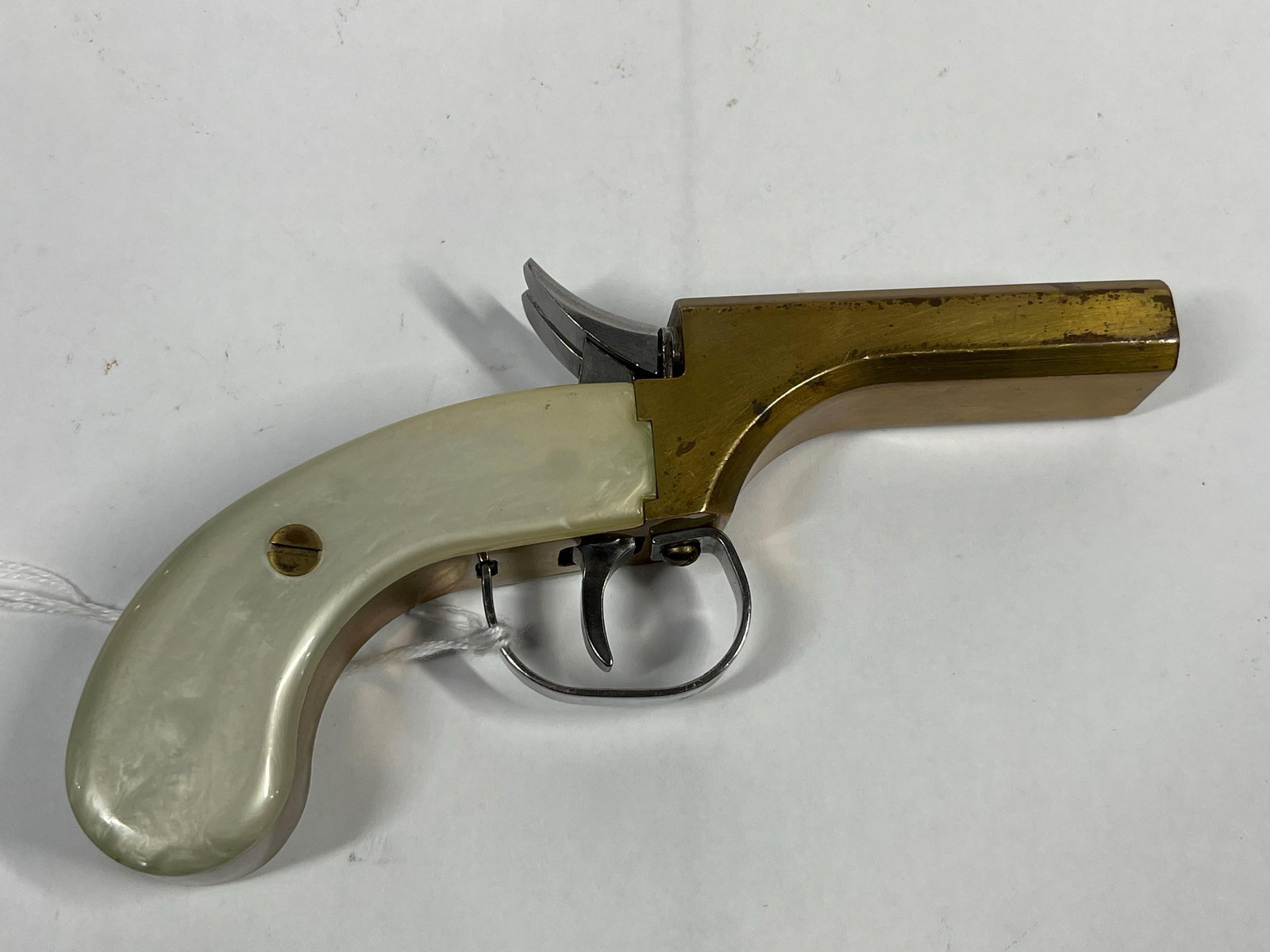 Double Barrel Black Powder Percussion Pistol: Marked 1647 above trigger. Brass with mother of pearl handle. Excellent condition