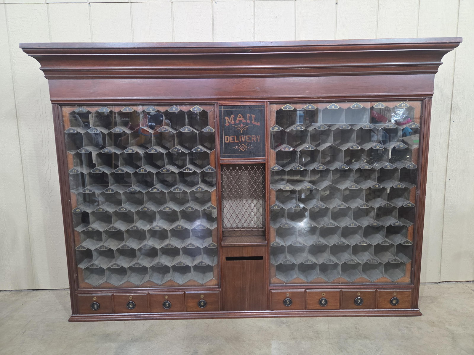 Outstanding Mail Delivery Postal Cabinet: With honey comb shaped tin interior numbered slots and a row of lock drawers along bottom. Has a great look and in great condition!! 67.5in wide 13.5in deep both at crown 47.5in tall.