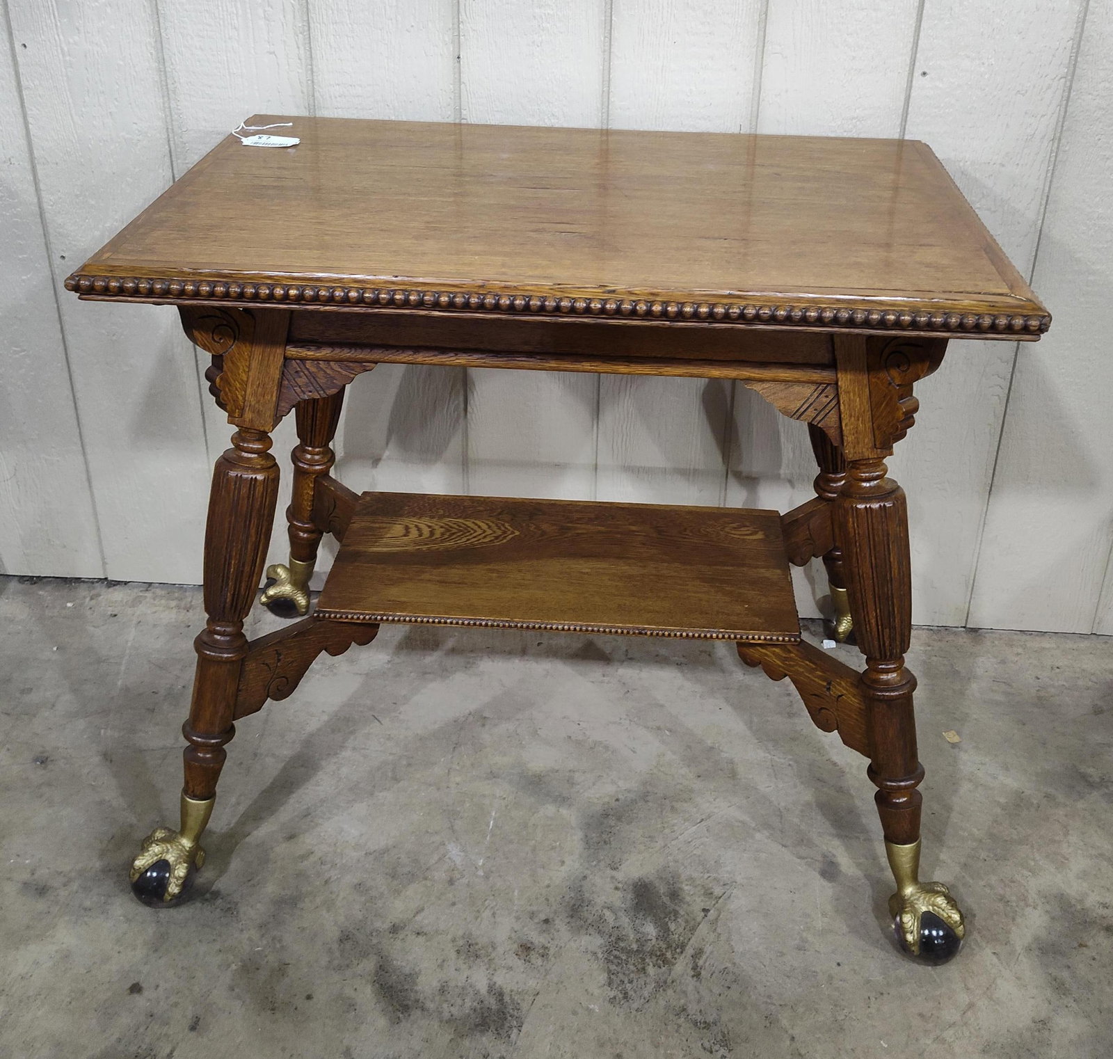 Gorgeous Early American Oak Library Table: Beautiful carved oak table with beaded border around top and bottom shelf, also features large gilted claw feet and glass ball bottoms. In real nice clean condition!!! Top is 24in X 36in 32in tall.