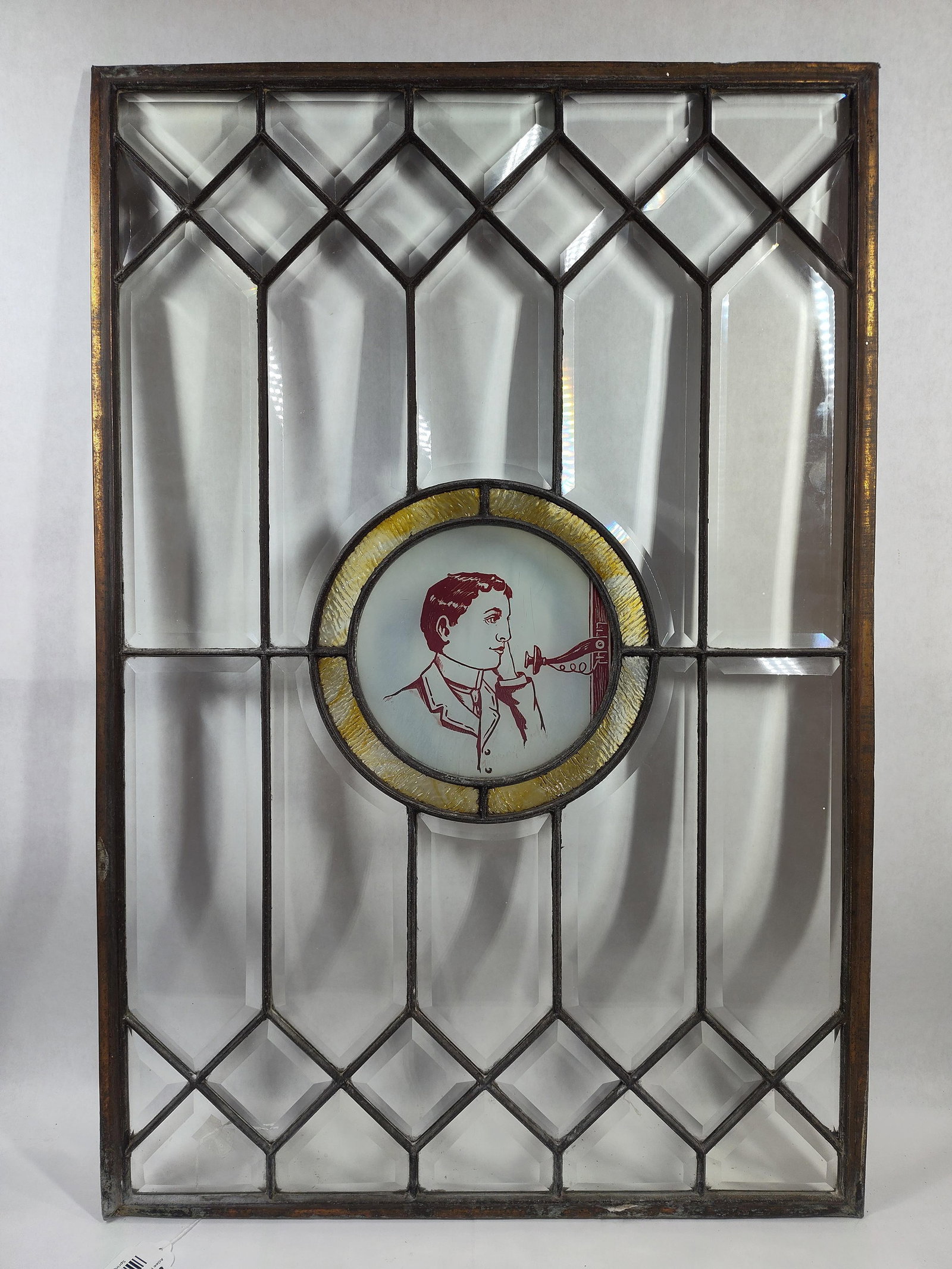 Beveled Leaded Glass Window w/ Center Medallion of Gentleman: Another nice beveled glass window with center medallion of Gentleman on phone. Center Medallion shows a crack, otherwise is great! 20in x 30in.