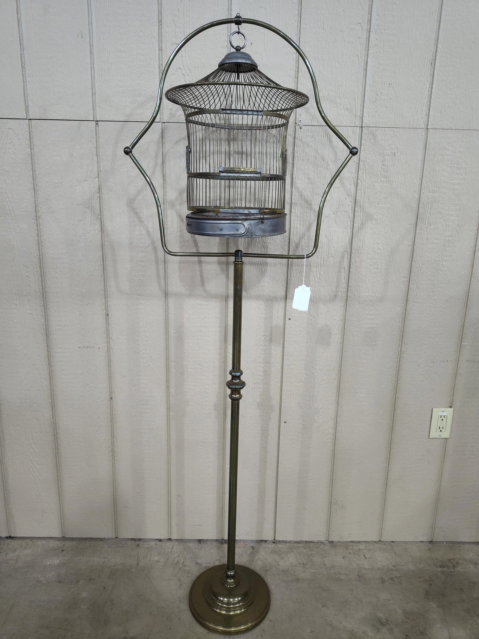 1920s Brass Bird Cage with stand: Brass cage and stand with metal bottom that shows some condition but overall is pretty nice. With decorative hole covers. 67in tall.