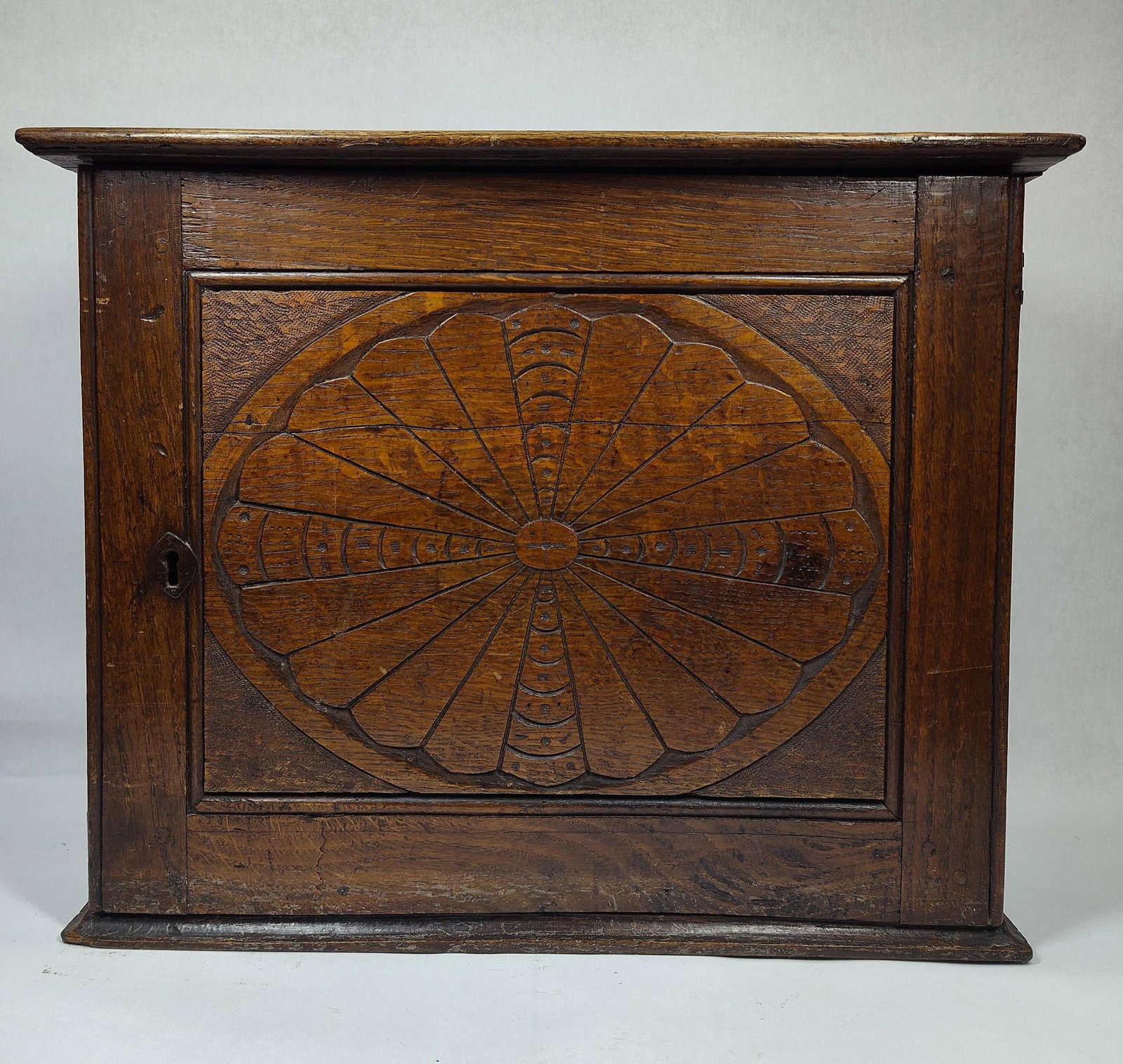 Early Oak Carved Hanging Medicine Cabinet: Very early oak cabinet with carved door. Has several drawers to interior. Shows several chips and cracks and appears backer has been replaced but still has a good look! 20in wide 10in deep 16in tall.