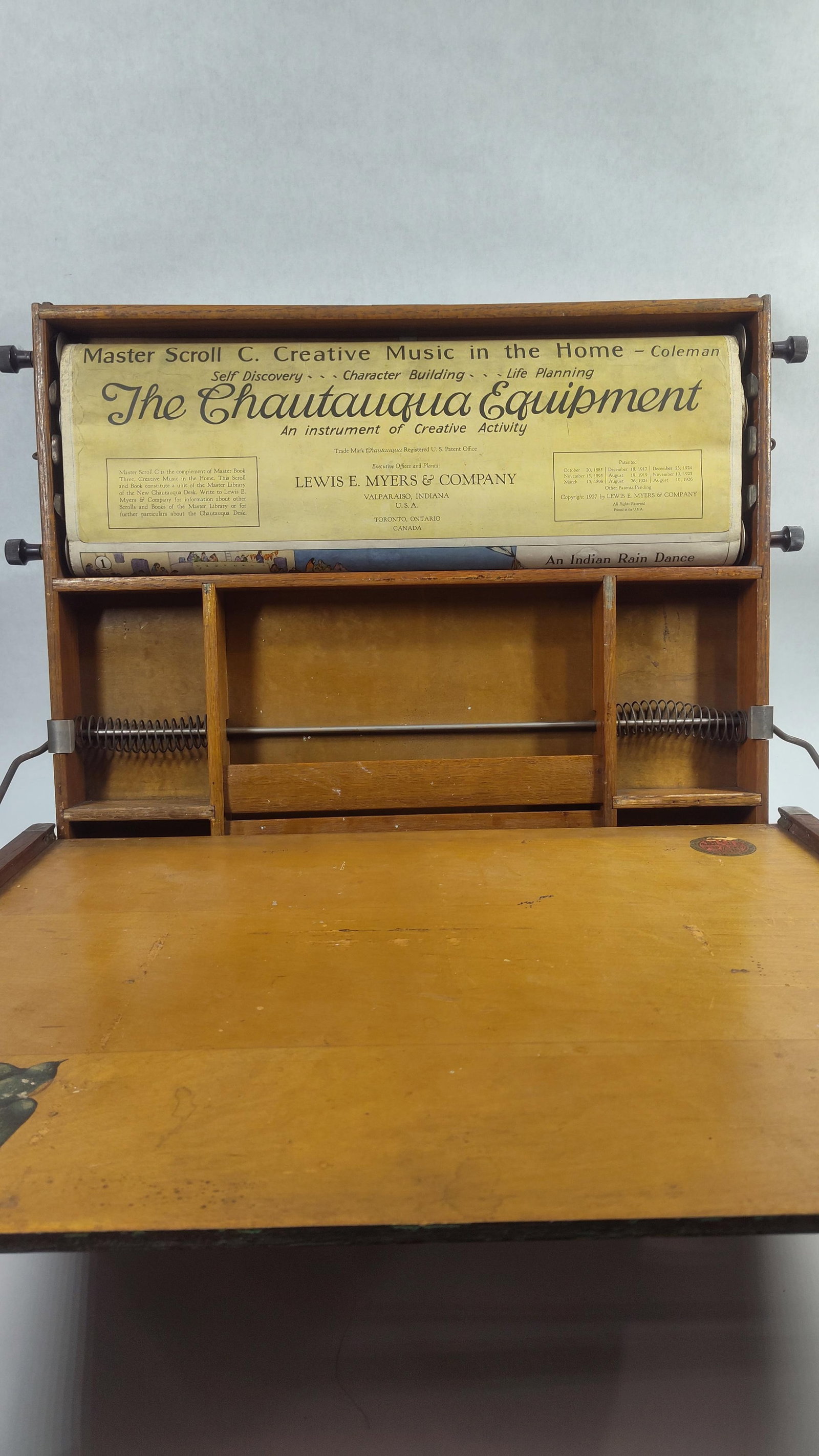 1927 Lewis E. Meyers Master Scroll of Creative Music: A vibrant scroll with many instrument and musical images. Upper board can be tilted to compact size. All parts appear to be in working condition. 22 x 16.5 