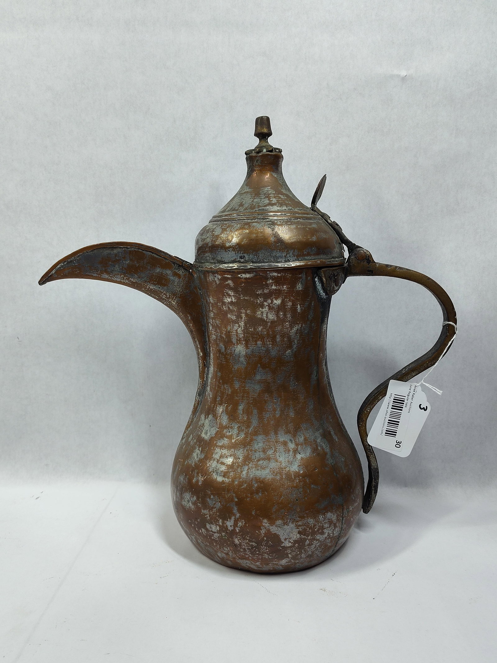 Middle Eastern Tinned Copper Dallah Coffee Pot: This Middle Eastern coffee pot, known as a dallah, is constructed from hand-hammered copper with remnants of a traditional tin-wash finish on both the interior and exterior. The vessel features a bulb
