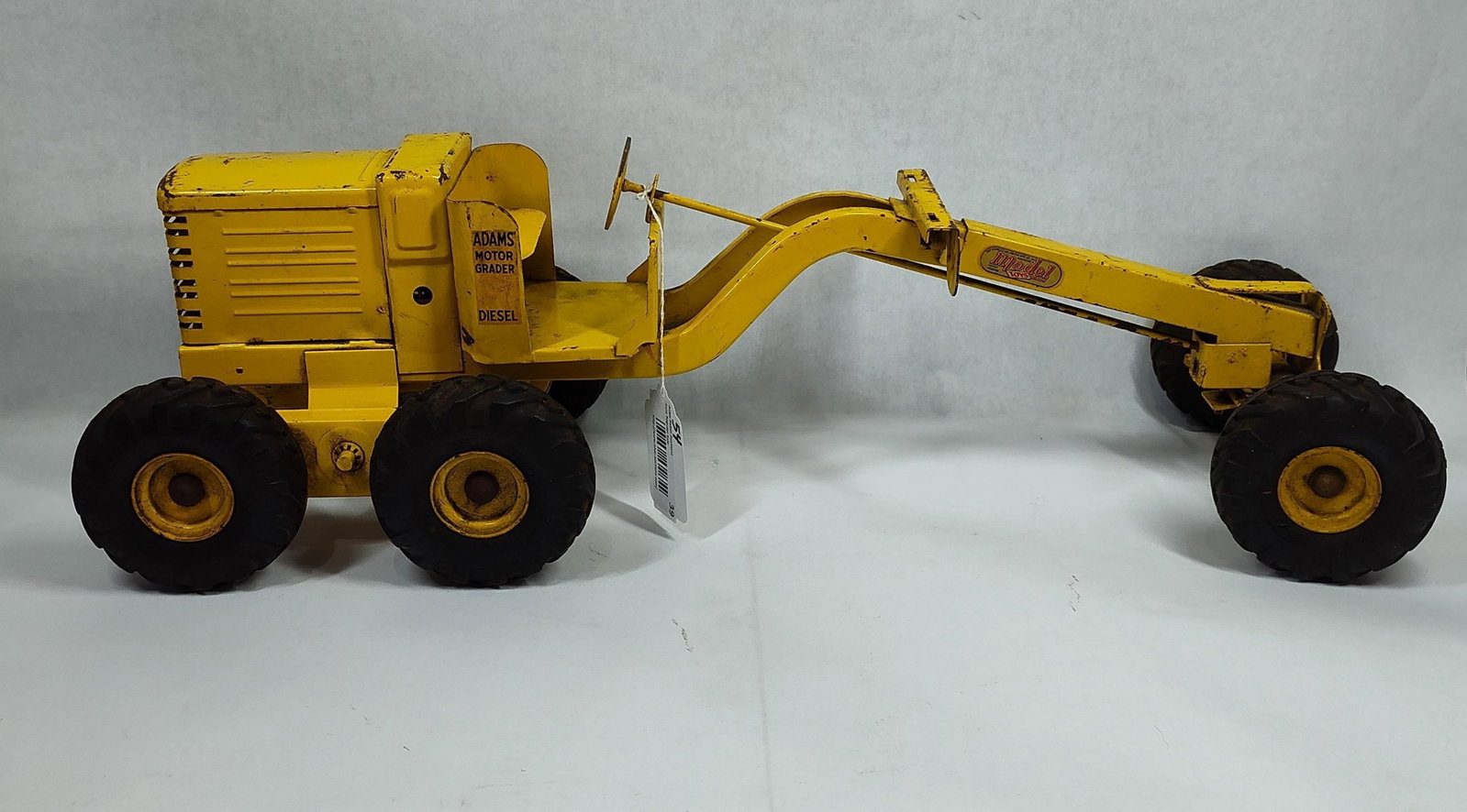 Doepke Model Toys Adams Motor Grader: AAdams Motor Grader manufactured by The Charles Wm. Doepke Manufacturing Company, Inc. of Rossmoyne, Ohio. The toy is constructed of heavy-gauge pressed steel and finished in yellow paint. It