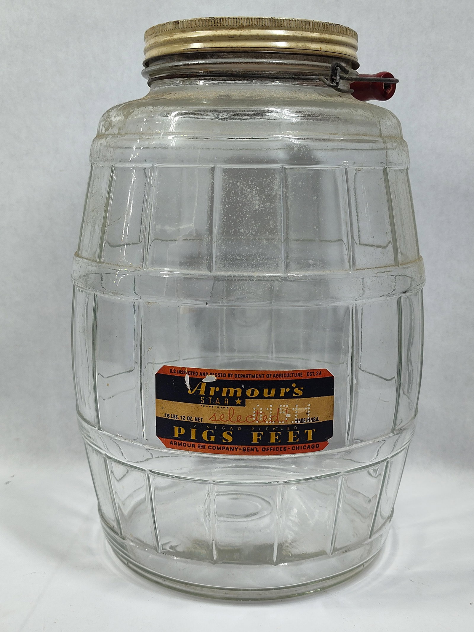 Armour and Company 16 Pound Glass Barrel Jar for Pickled Pigs Feet: A largeadvertising jar manufactured for Armour and Company of Chicago. The jar is constructed from clear glass molded into a barrel shape with vertical staves and horizontal hoops. It features a