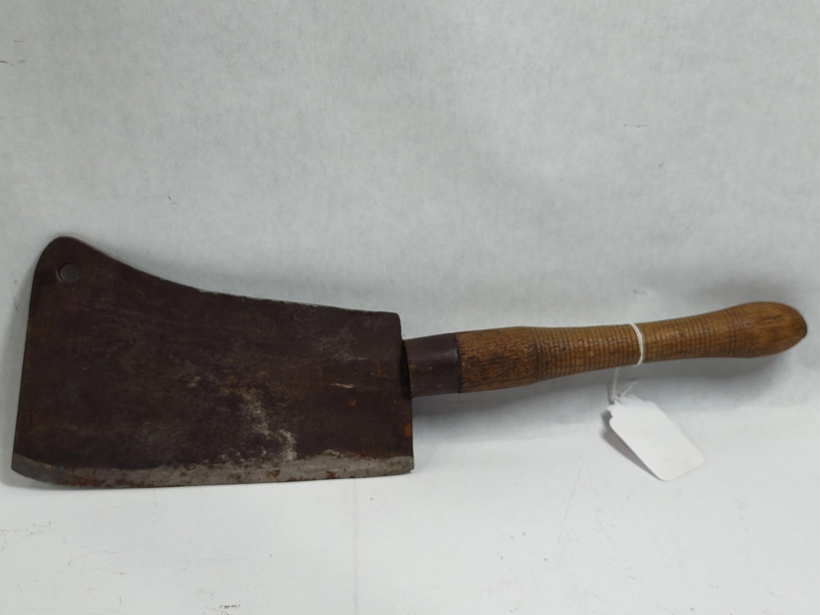 Antique Carbon Steel Meat Splitter with Turned Hardwood Handle: This antique butchery tool is a meat splitter designed for heavy-duty carcass splitting. The implement features a large, rectangular carbon steel blade with a curved upper profile and a circular hangi