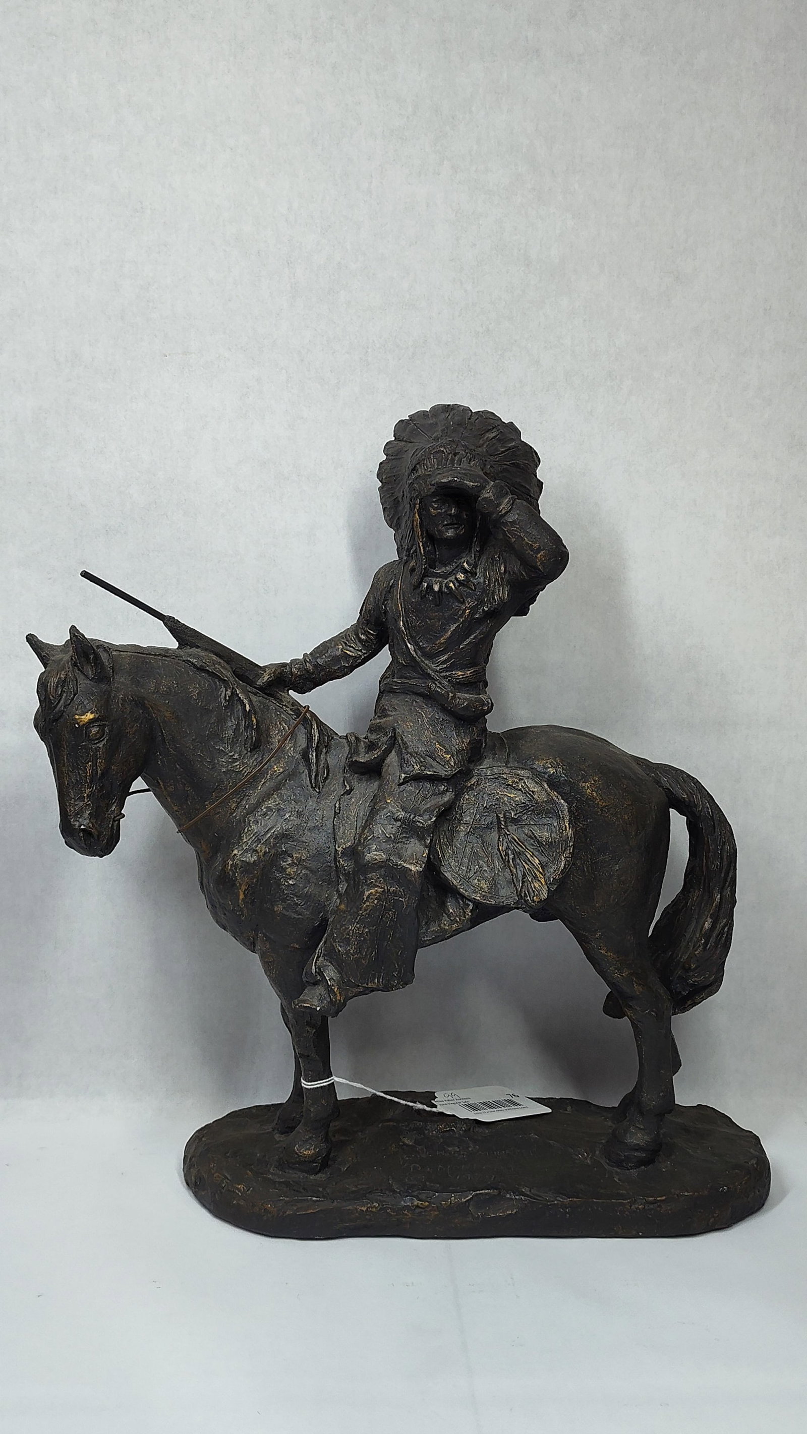 D. Monfort, Chief Native American on Horseback Composition Sculpture, 1979: This cast composition sculpture, dated 1979, portrays a Native American chief in a traditional feathered headdress mounted on a horse. The figure is positioned with the right hand shading the eyes