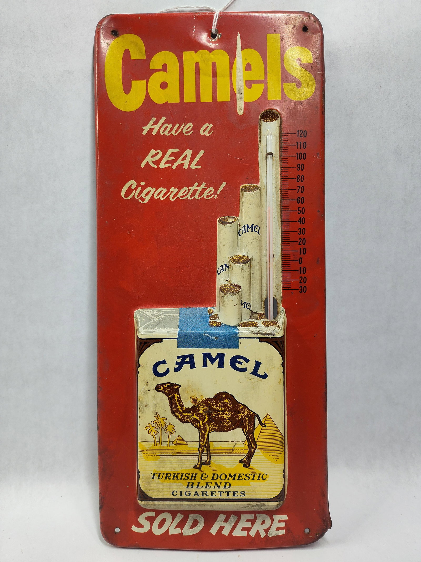 Camel Cigarettes Embossed Tin Lithograph Thermometer Sign by Robertson: This is an original mid-20th-century vertical advertising thermometer for Camel Cigarettes, manufactured by the Robertson Steel & Iron Co. of Springfield, Ohio. The sign is constructed of