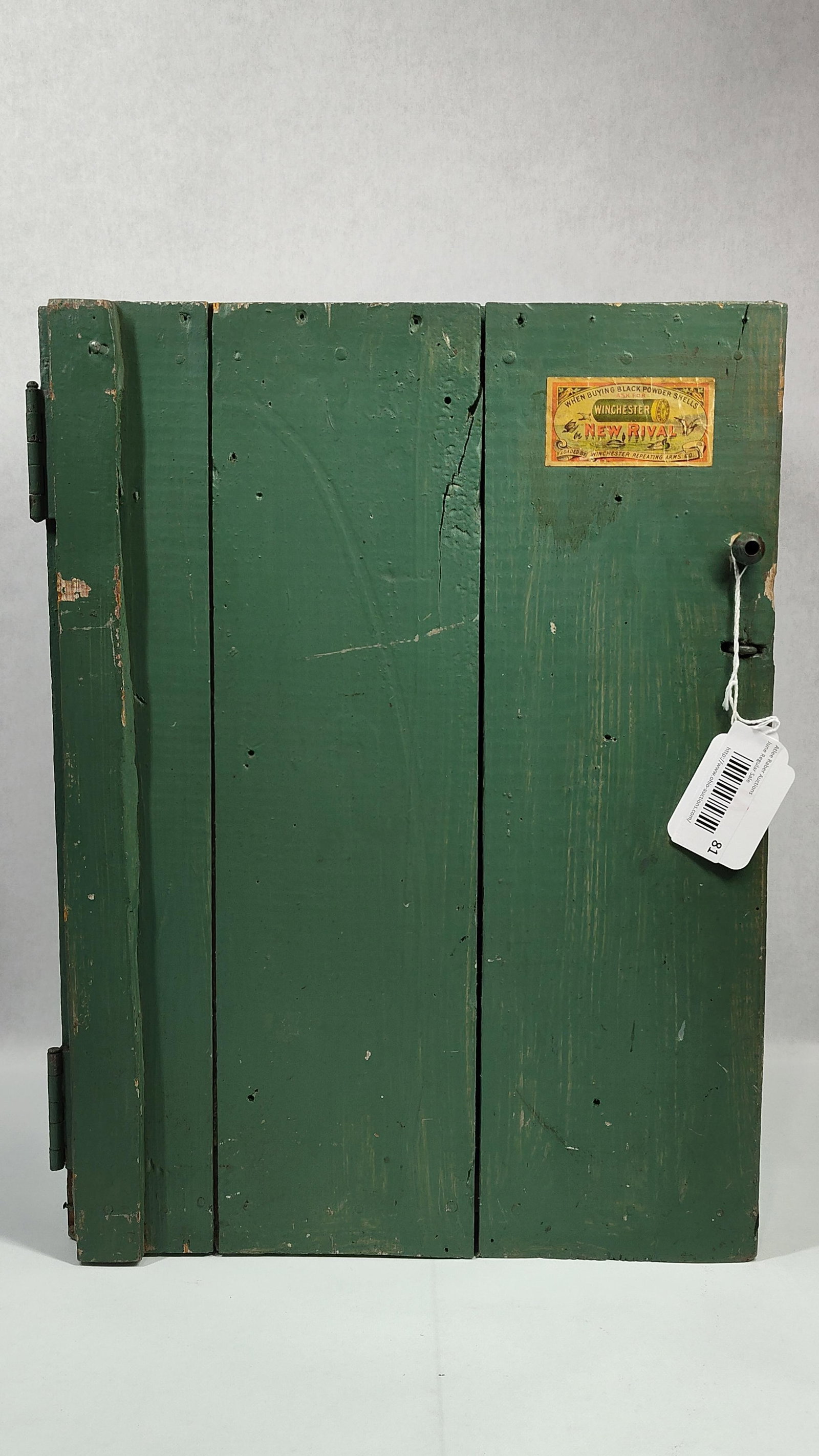 Primitive Green Painted Wooden Cupboard with Winchester Advertising Label and Repurposed Cheese Box: A primitive handmade wooden storage cabinet featuring a single hinged door and an interior fitted with twelve drawers. The exterior is constructed from wooden planks finished in forest green paint