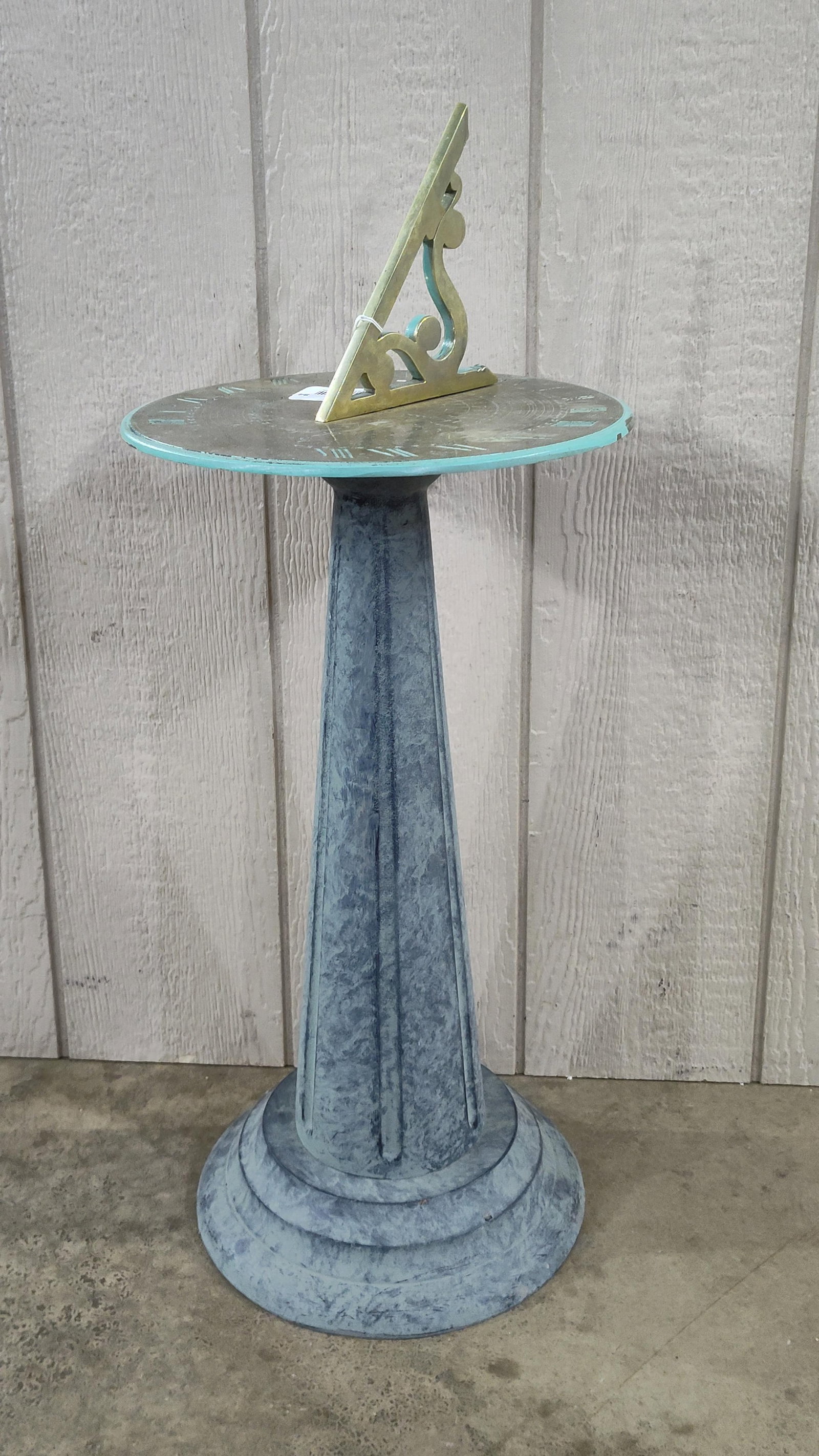 Traditional Garden Sundial on a Painted Cast Stone Pedestal: A decorative garden sundial featuring a circular brass dial plate mounted on a fluted pedestal. The pedestal is constructed from cast stone with a tapered fluted shaft and a stepped circular base, fin