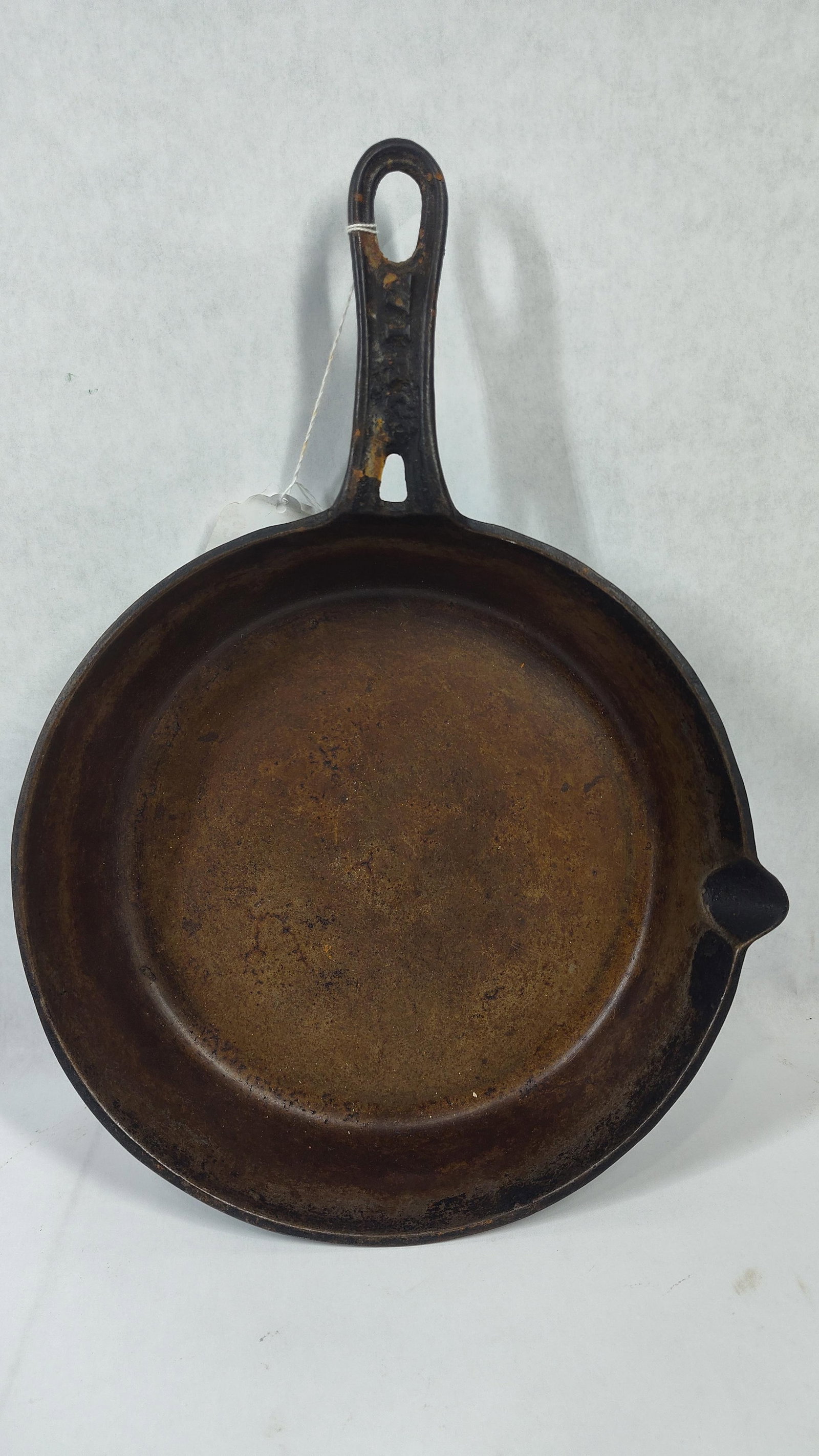Viko Cast Iron Skillet with Single Pour Spout and Heat Ring: Acast iron skillet featuring a single pour spout and a raised heat ring on the underside. The handle is embossed on the top surface with the brand name VIKO in raised capital letters. The handle