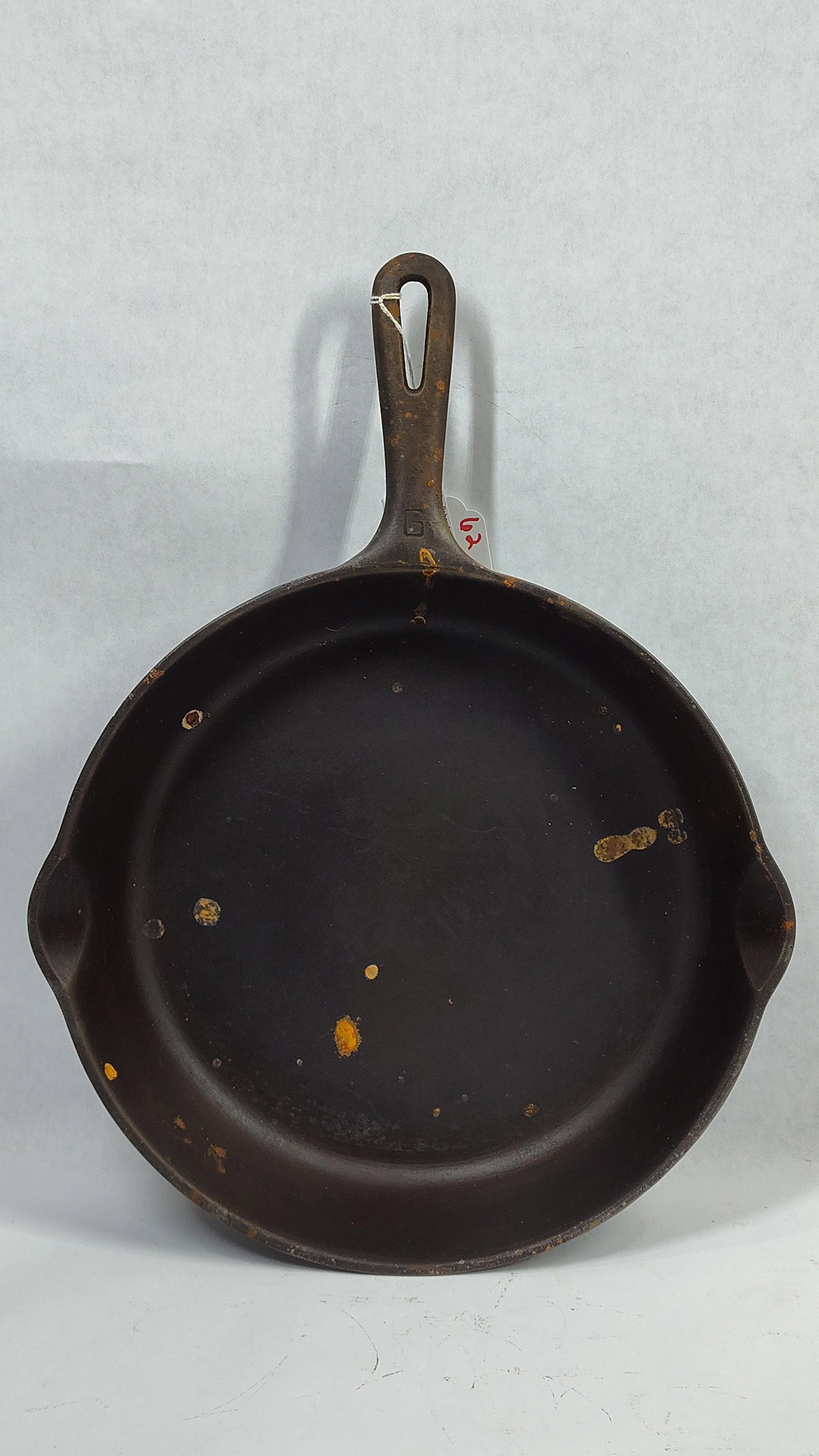 Griswold 11 1/4 Inch Cast Iron Skillet: This is acast iron skillet manufactured by the Griswold Manufacturing Co. of Erie, Pennsylvania. The skillet features a circular form with two integrated pouring spouts and a handle with a teardrop-sh